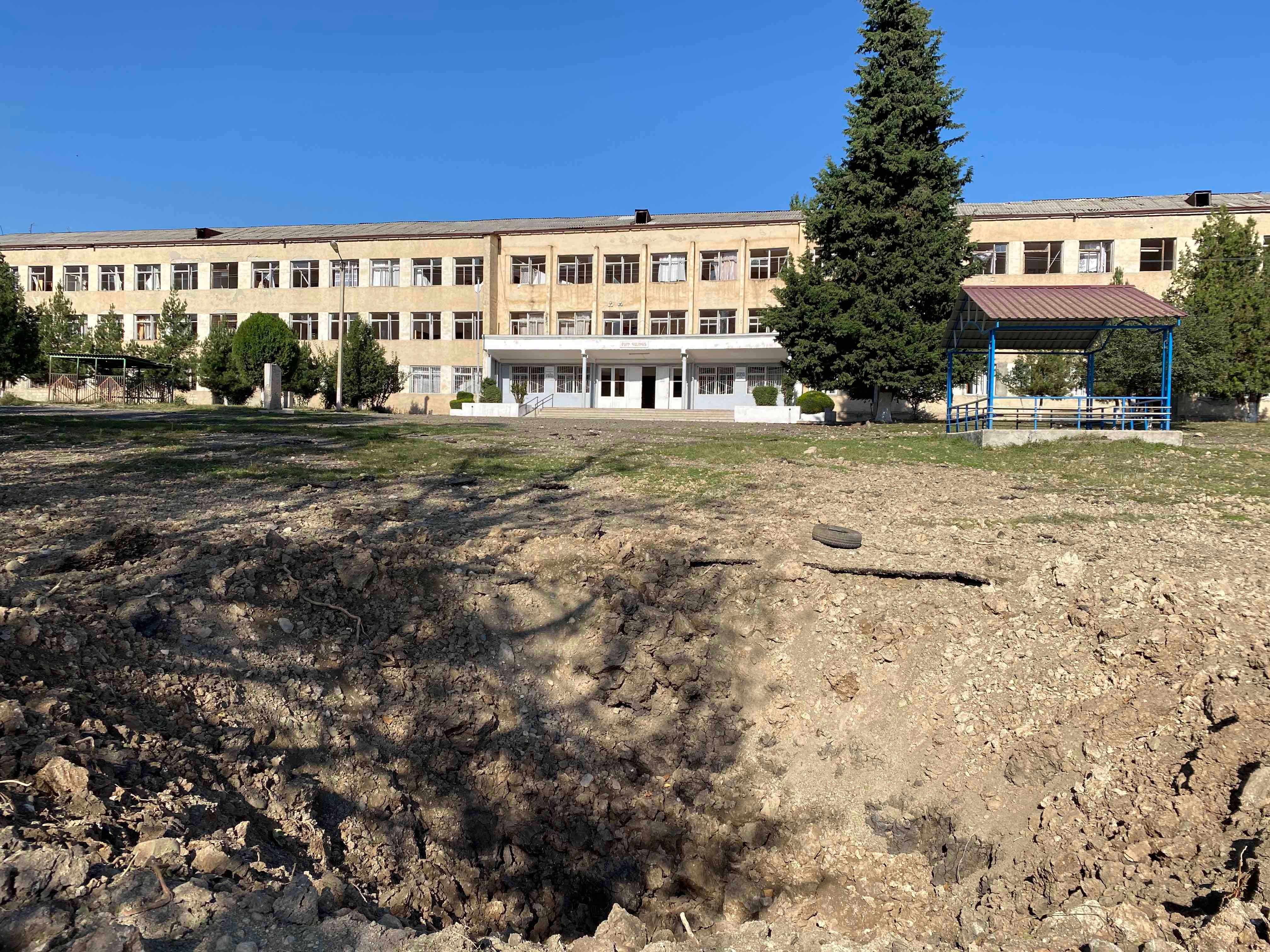 Воронка от азербайджанского боеприпаса, попавшего примерно в 40 м перед фасадом школы № 10 в Степанакерте. Взрывной волной выбило окна и повредило десятки классов. 