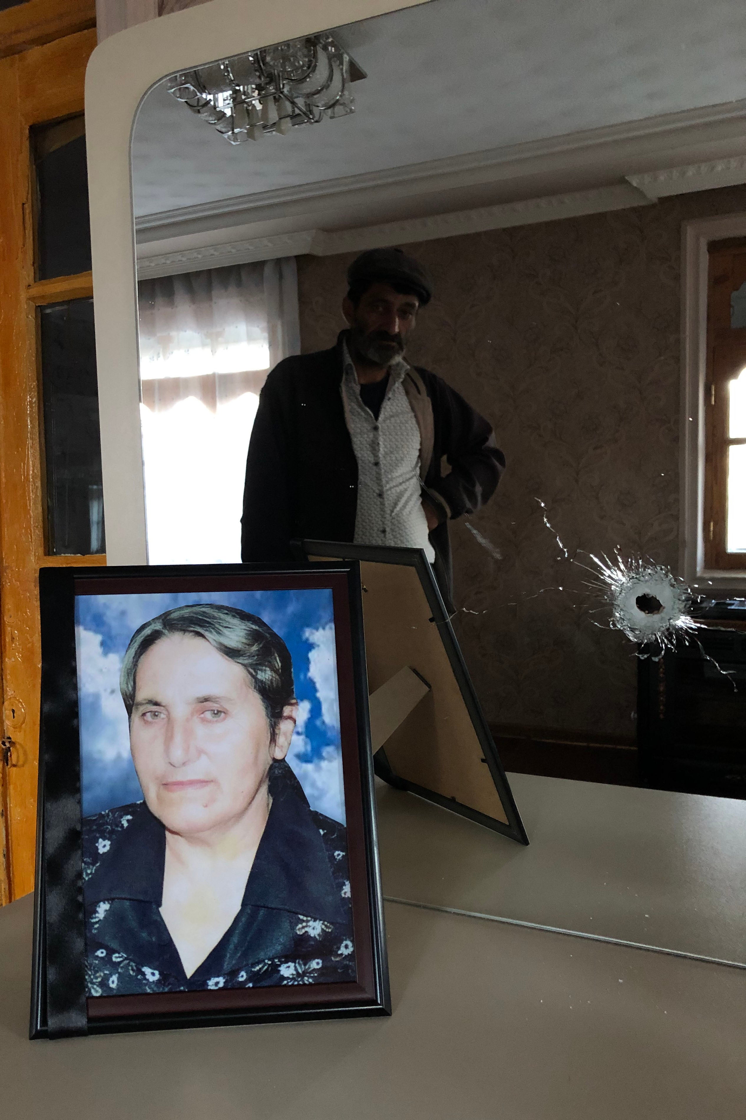 Яшар Аббасов хранит фотографию жены Разии на комоде с зеркалом, которое тоже пробило осколком в день, когда она погибла. Село Кызылгаджылы, Азербайджан. 