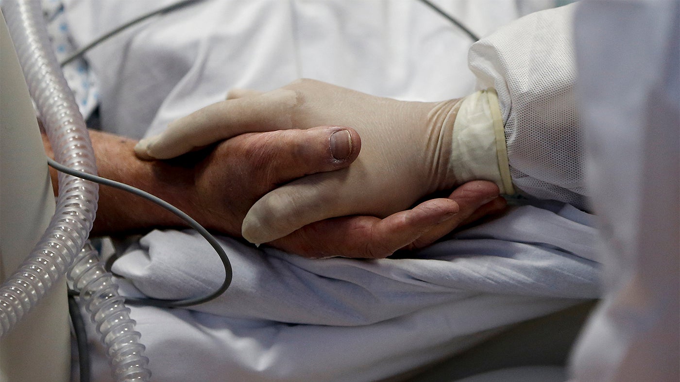 Eine Pflegekraft hält die Hände eines COVID-19-Patienten auf der Intensivstation des Casal Palocco Krankenhauses in Rom, 20. Oktober 2020. 