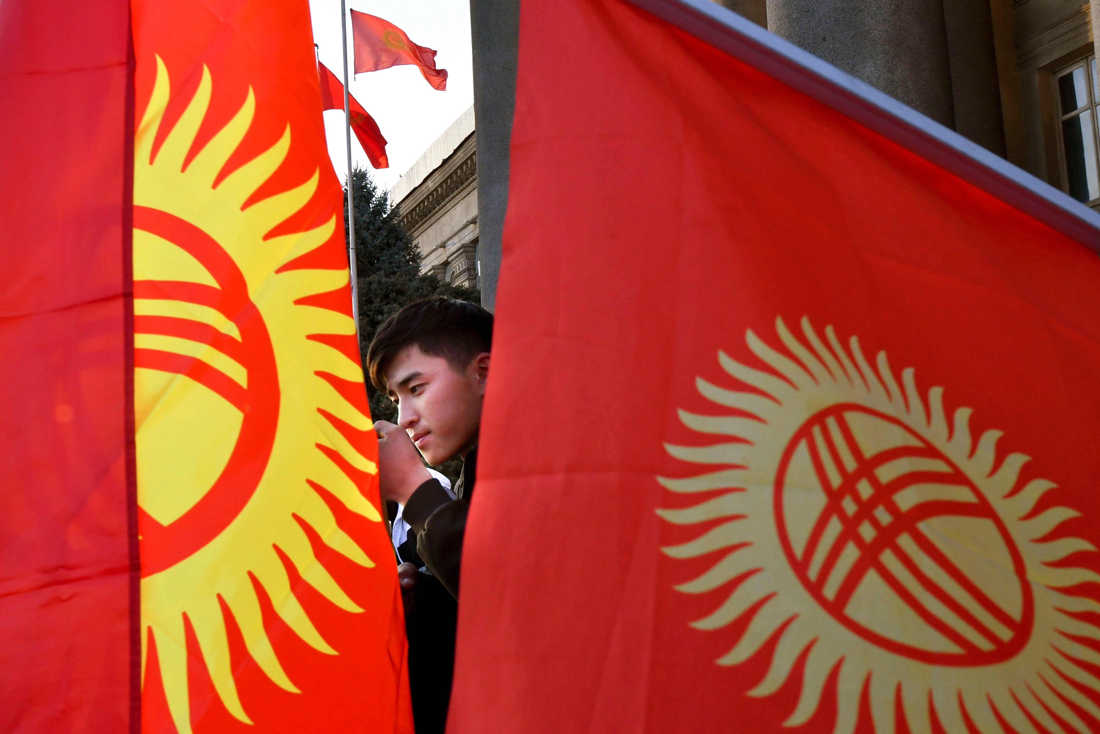 A protester listens to a speaker during a rally in front of the government building in Bishkek, Kyrgyzstan, Wednesday, October 14, 2020. 
