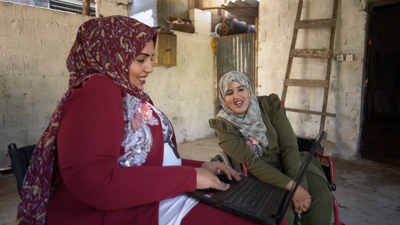 Doaa Qashlan and her sister Abeer look at a laptop during an interview with Human Rights Watch, November 18, 2020.