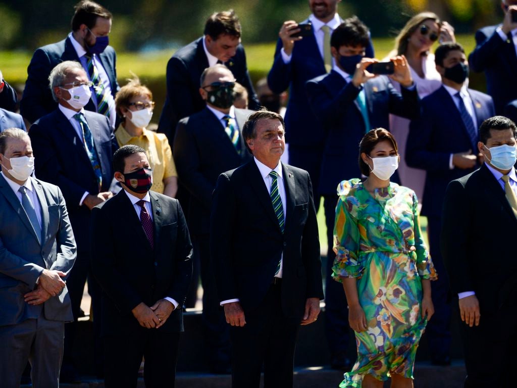 Brazil's President Jair Bolsonaro, without a mask, attends a ceremony at the Presidential Palace in Brasilia, along with ministers and other authorities, most of whom are wearing mask, on September 7, 2020. 