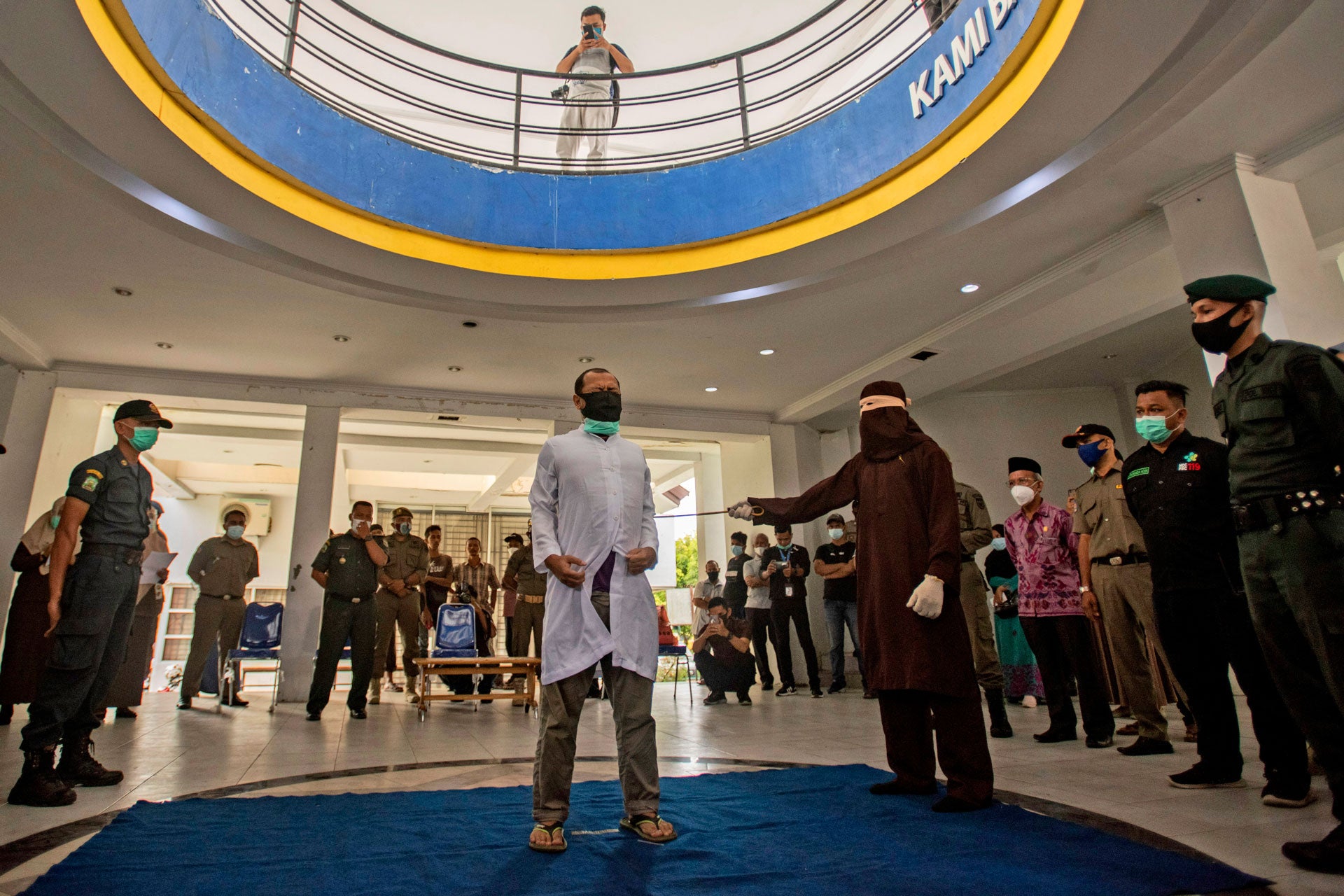 Un responsable de l’application de la charia à Banda Aceh, dans la province d'Aceh en Indonésie, frappe un homme accusé de rapports homosexuels à coups de canne en rotin lors d’une flagellation publique, le 28 janvier 2021. L’homme subissant la flagellation, ainsi qu’un deuxième homme, ont chacun été condamnés à 77 coups de bâton.