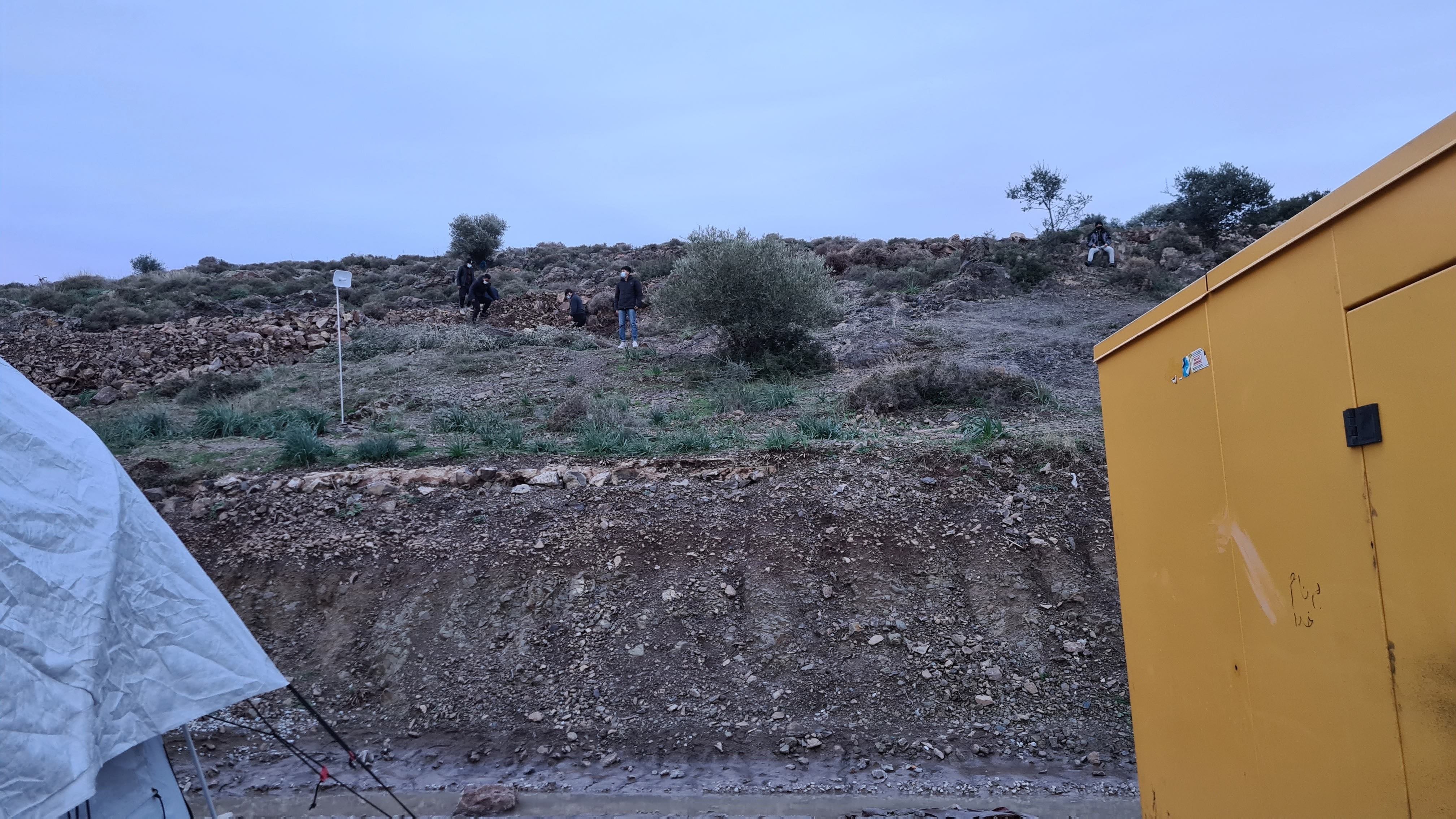 Four camp residents stand on Mavrovouni hill