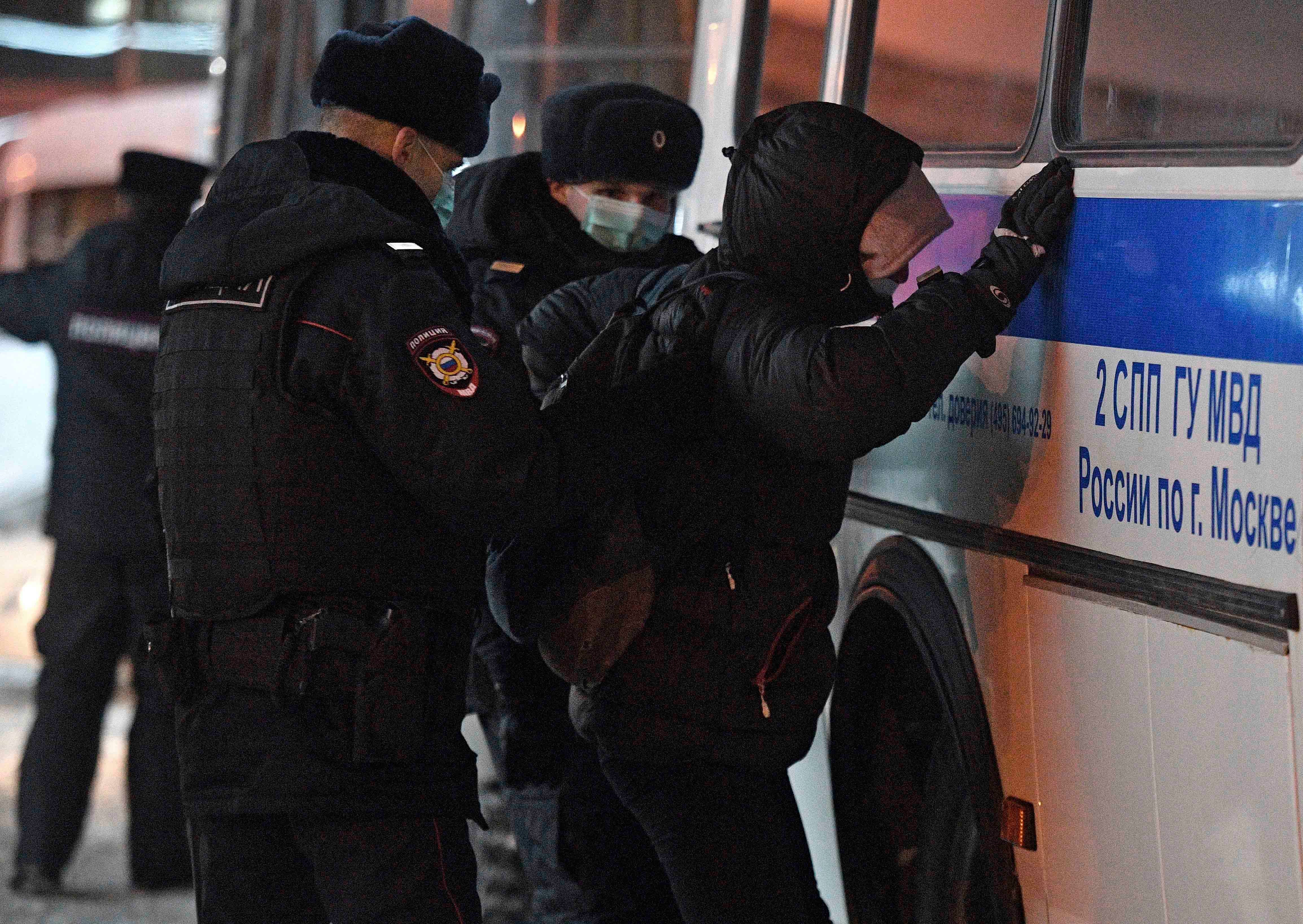 Police officers detaining Alexei Navalny's supporter at Vnukovo airport, Moscow.