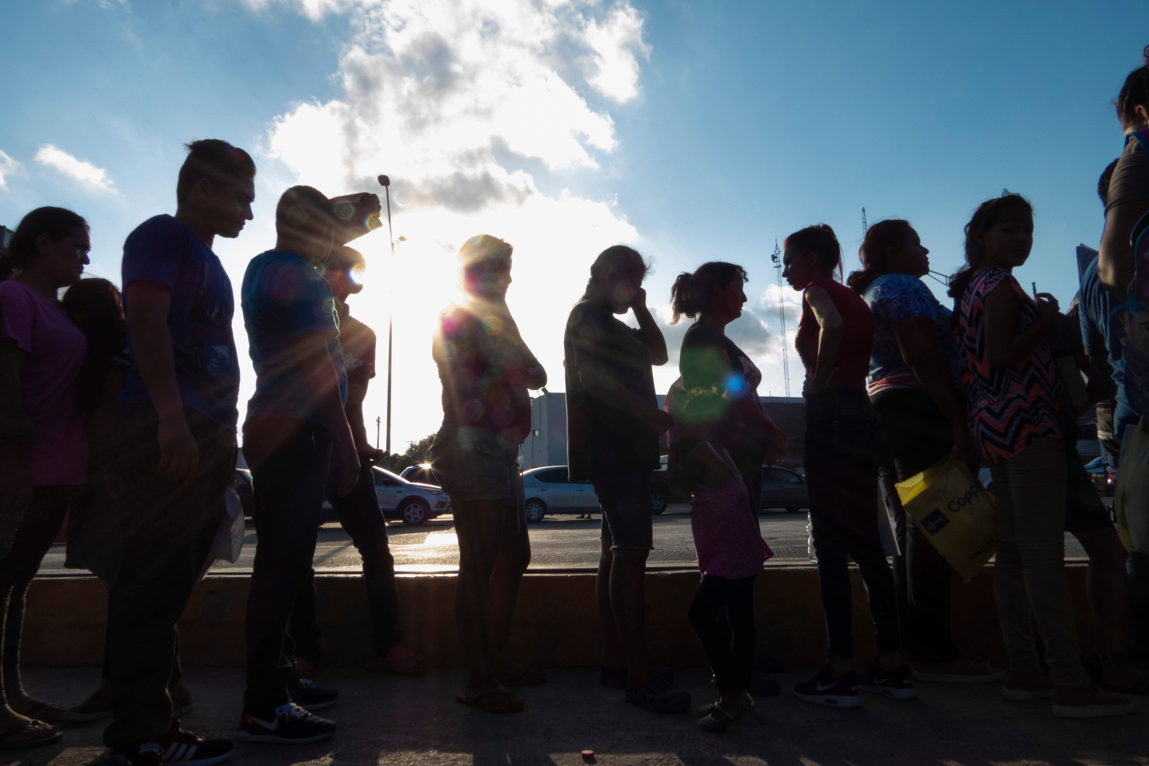 Migrants seeking asylum wait in line with their case paperwork to meet with an attorney on Oct. 5, 2019, during a weekly trip by volunteers, lawyers, paralegals and interpreters to the migrant campsite outside El Puente Nuevo in Matamoros, Mexico.