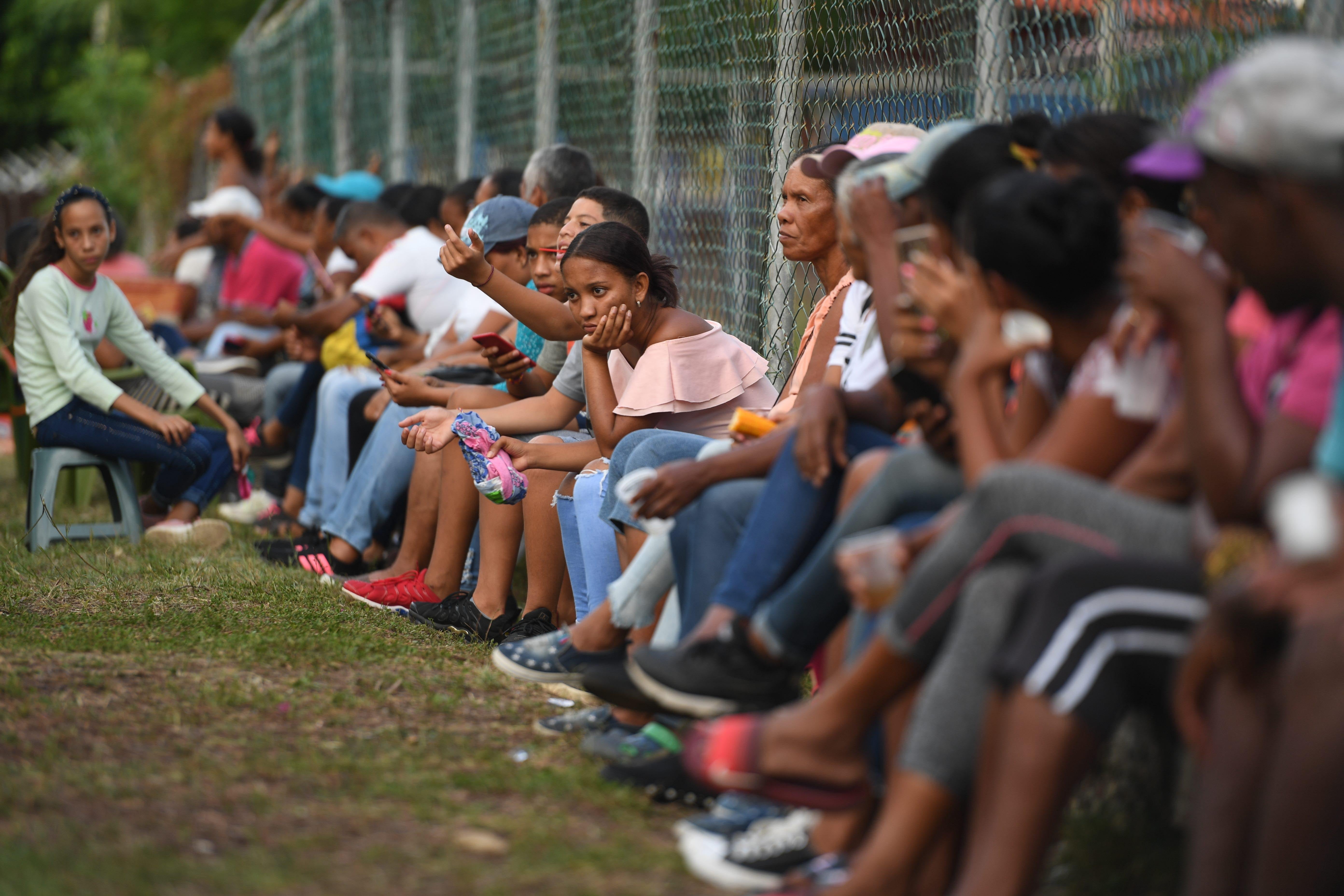 Familiares y amigos de migrantes venezolanos que fallecieron al hundirse el barco en el que viajaban a Trinidad y Tobago  esperan noticias sobre la recuperación de sus cuerpos, en Güiria, Venezuela, el 18 de diciembre de 2020.