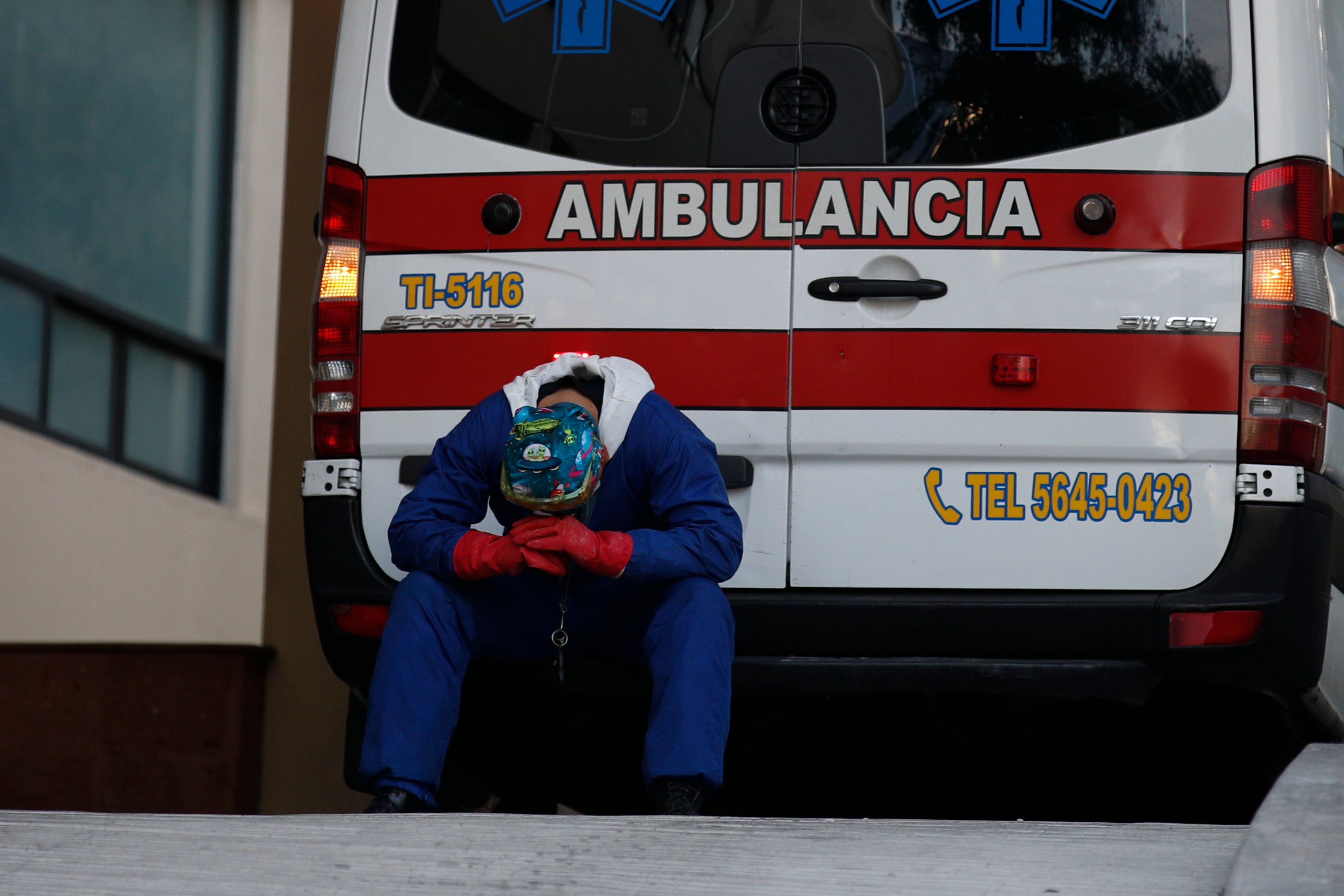 A paramedic rests behind his ambulance, as ambulance staff wait hours for the Covid-19 patients they are transporting to be admitted, at Siglo XXI National Medical Center in Mexico City, Thursday, Jan. 7, 2021. 