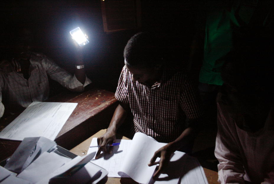 Election officials count votes by flashlight inside a school used as a polling station during elections in Niamey, Niger, Sunday, March 20, 2016.