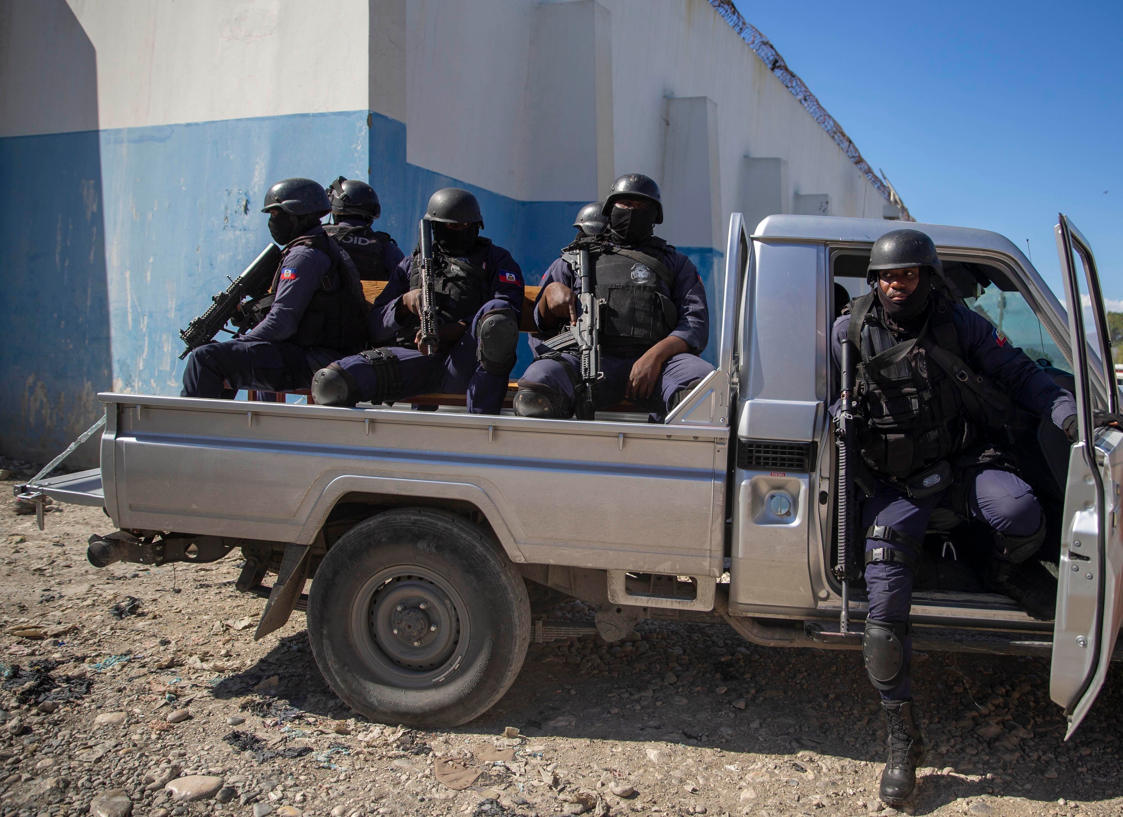 Heavily armed police are part of the group delivering Supreme Court justice Yvickel Dabrésil along with other detained individuals into custody at the penitentiary in Croix-des-Bouquets, Haiti, Feb. 9, 2021.