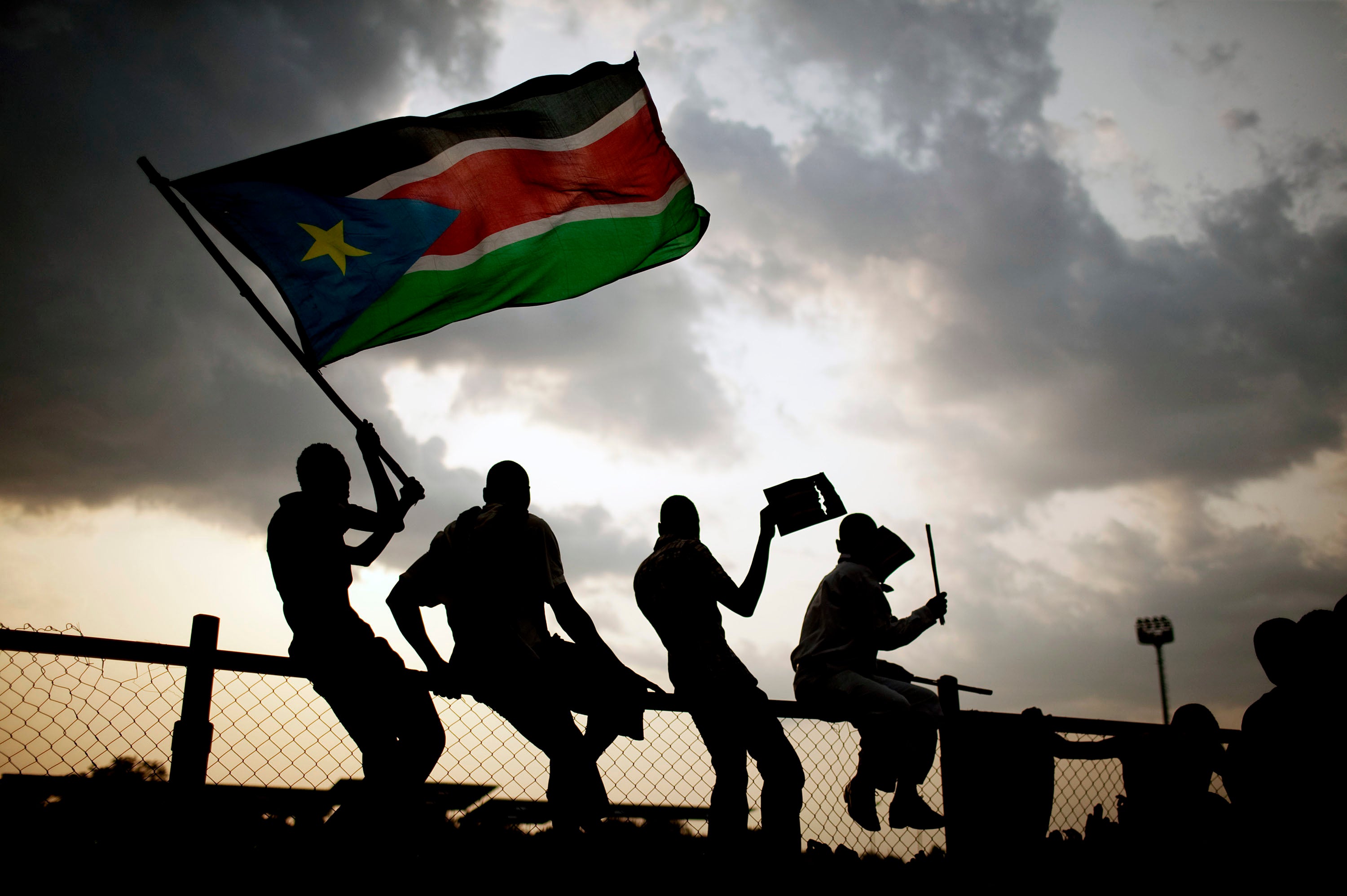 Southern Sudanese wave the national flag and cheer at South Sudan's first national soccer match after the country declared its independence, in the capital Juba on July 10, 2011