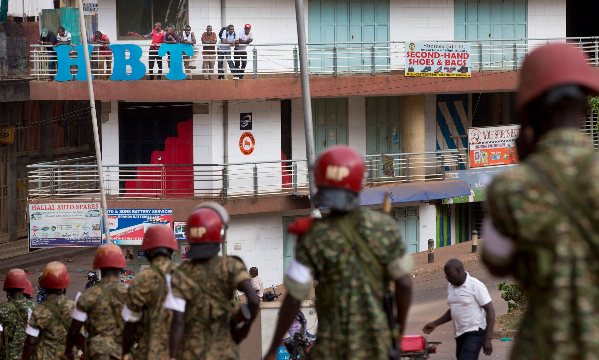 In this file photo, people look down from a balcony as military police deploy in downtown Kampala, Uganda, February 20, 2016. 