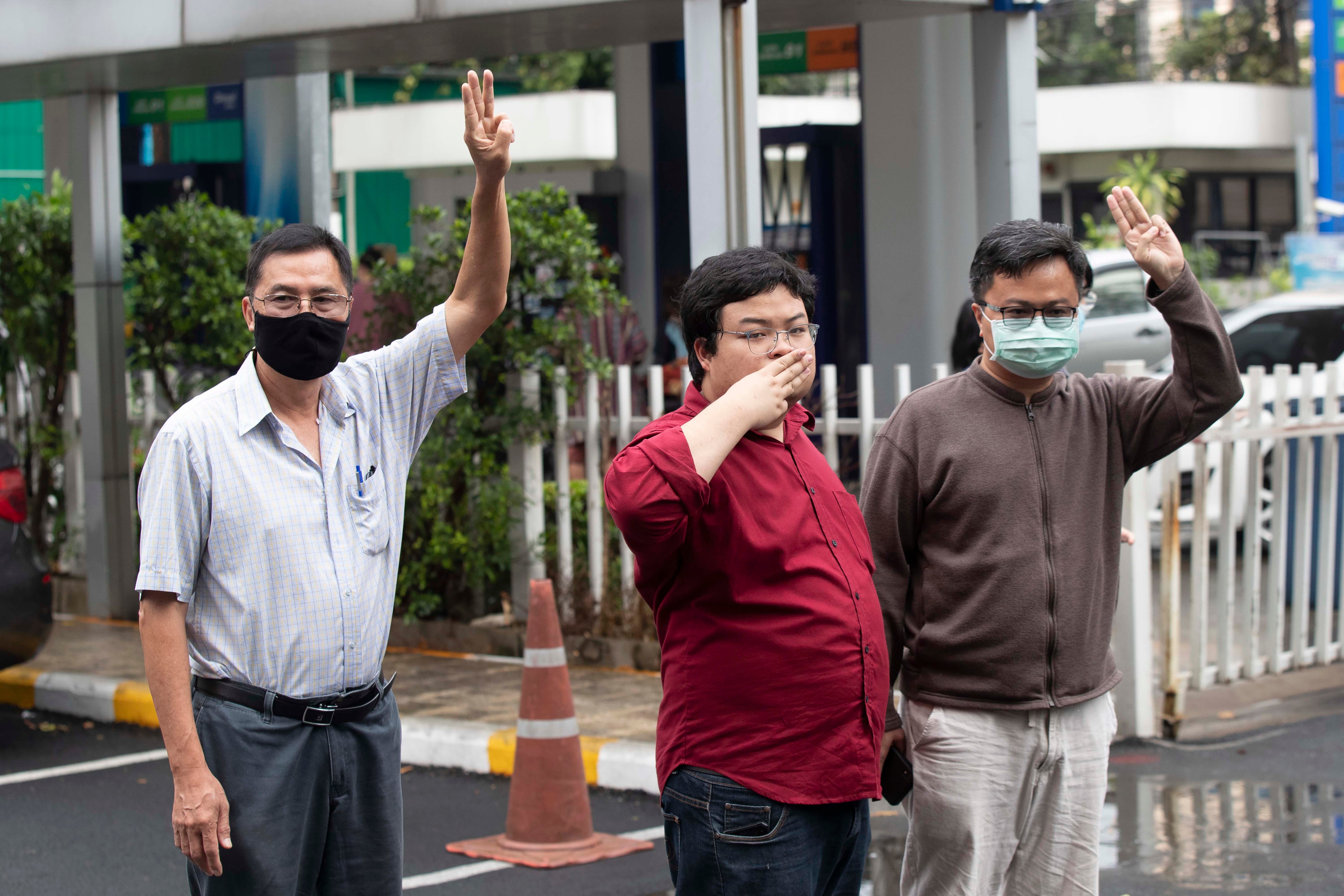 Activist Somyot Pruksakasemsuk, left Parit Chiwarak, and Arnon Nampha raise a three-finger salute, a symbol of resistance, as they arrive at Criminal court in Bangkok, Thailand, Tuesday, Feb. 9, 2021.