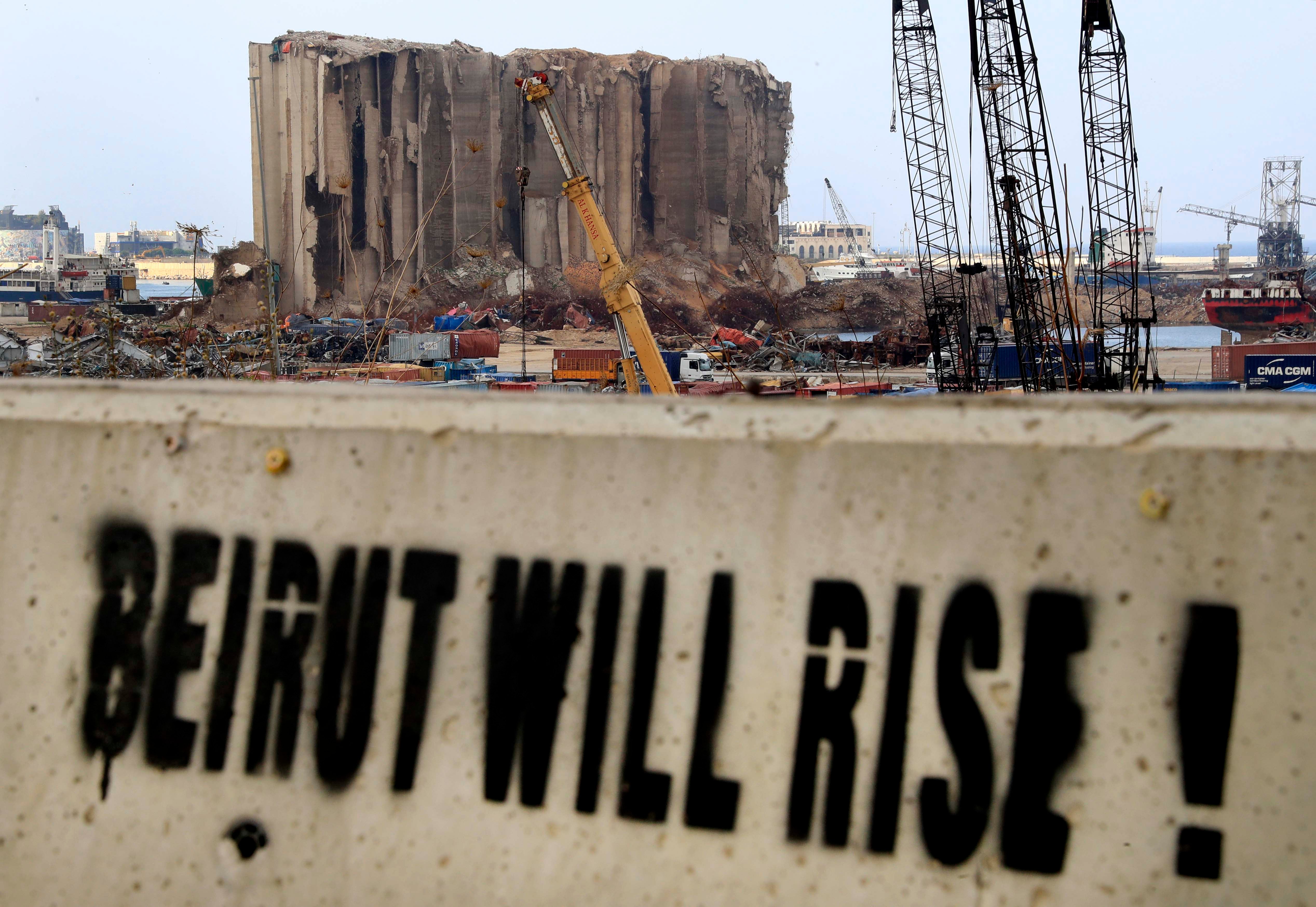 A slogan painted on a barrier in front of towering grain silos gutted in the massive August 2020 explosion at the Beirut port that claimed the lives of more than 200 people, December 2, 2020.