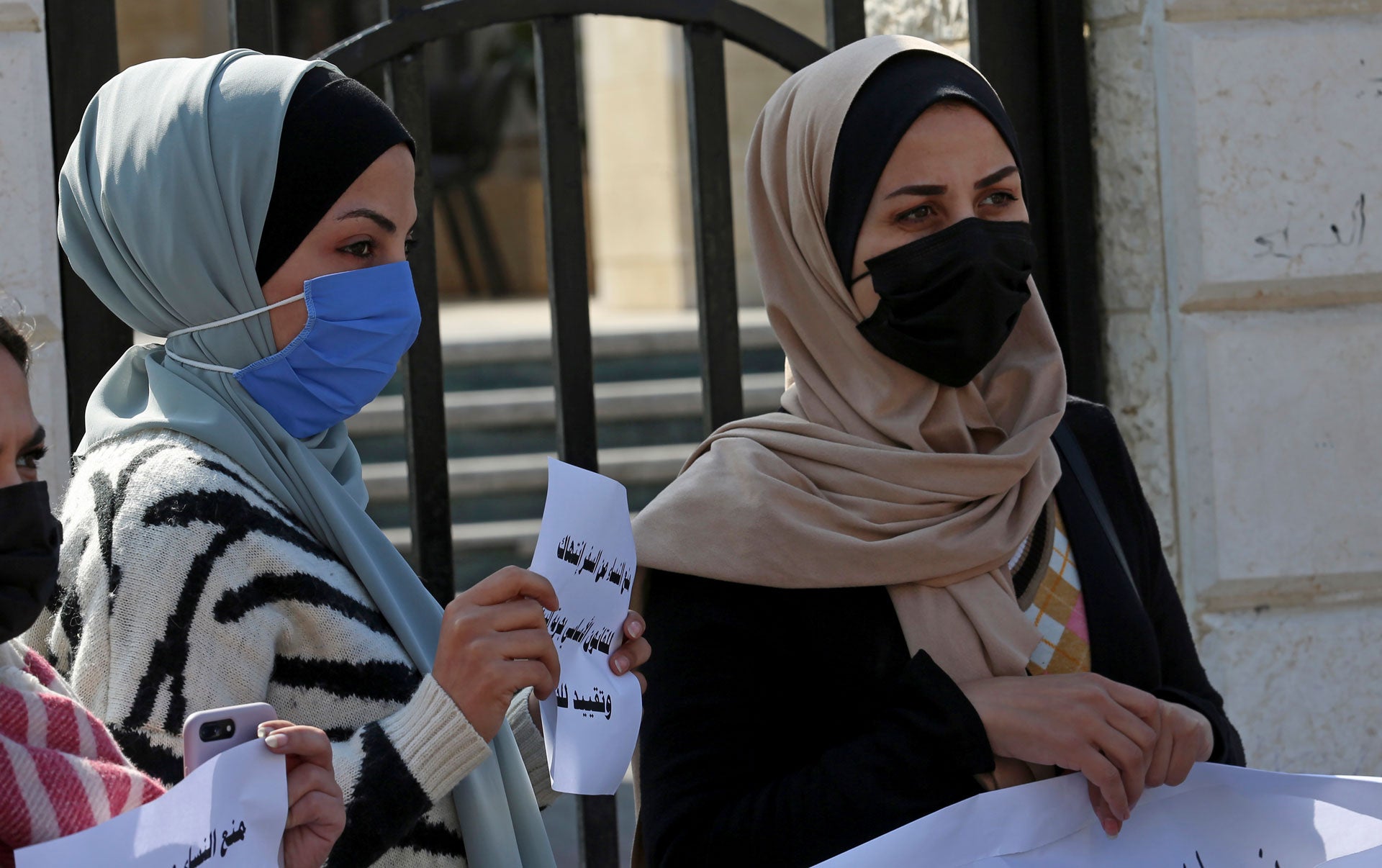נשים נושאות שלטים במהלך הפגנה נגד החלטת מועצת השריעה העליונה בעזה, האוסרת על נשים לנסוע מהרצועה או אליה ללא אישור ה"אפוטרופוס" שלהן, בעיר עזה, ב-16 בפברואר 2021. 