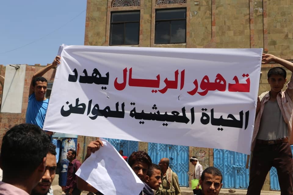 Demonstrators hold a banner that reads, "the depreciation of Yemen's rial currency threatens citizens' livelihood," in Taiz, Yemen, December 2018.