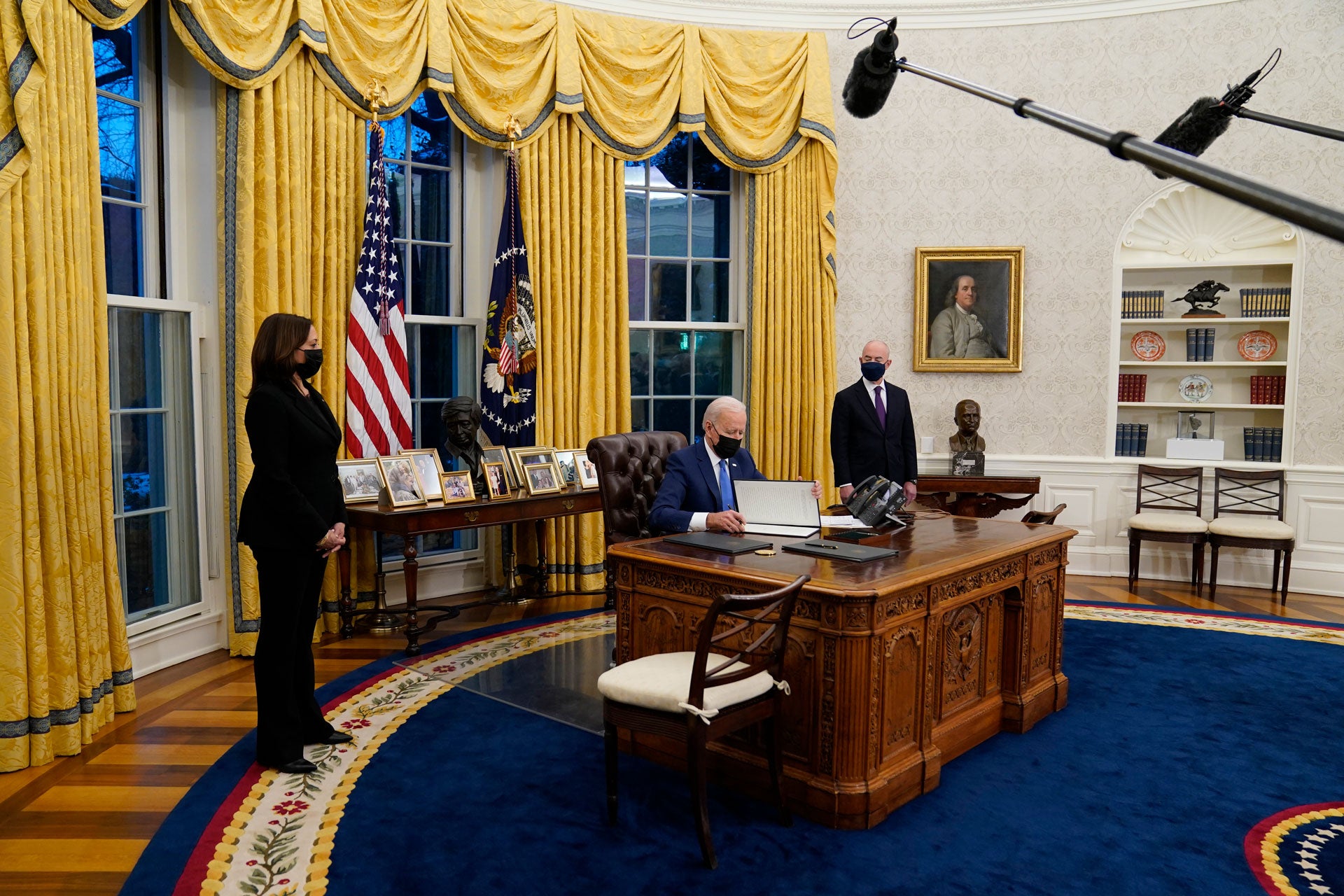 Vice President Kamala Harris, left, and Secretary of Homeland Security Alejandro Mayorkas, right, watch as President Joe Biden signs an executive order on immigration in the Oval Office of the White House in Washington, February 2, 2021.