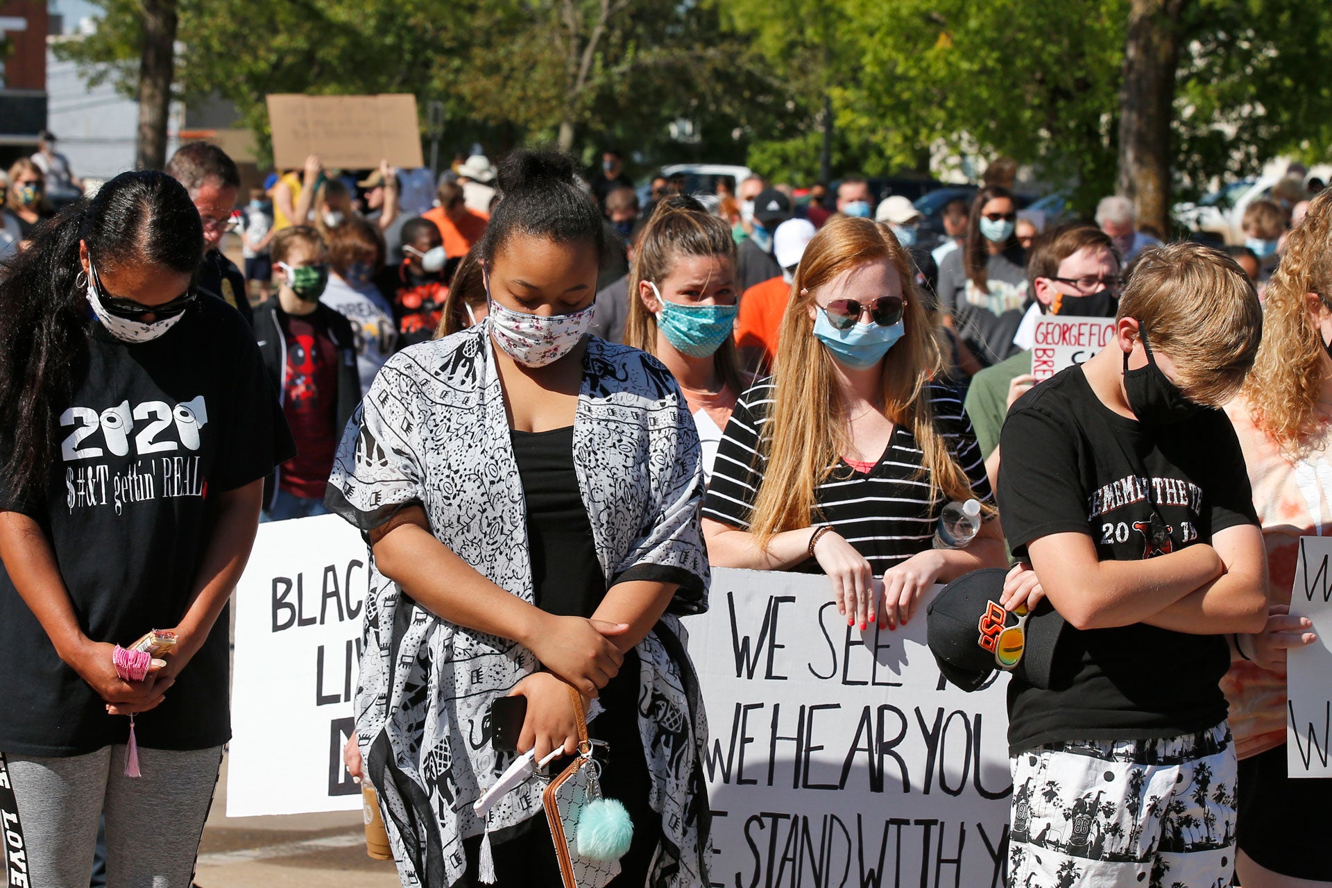 People bow their heads during a rally to protest the death of George Floyd, June 3, 2020, in Stillwater, Oklahoma.