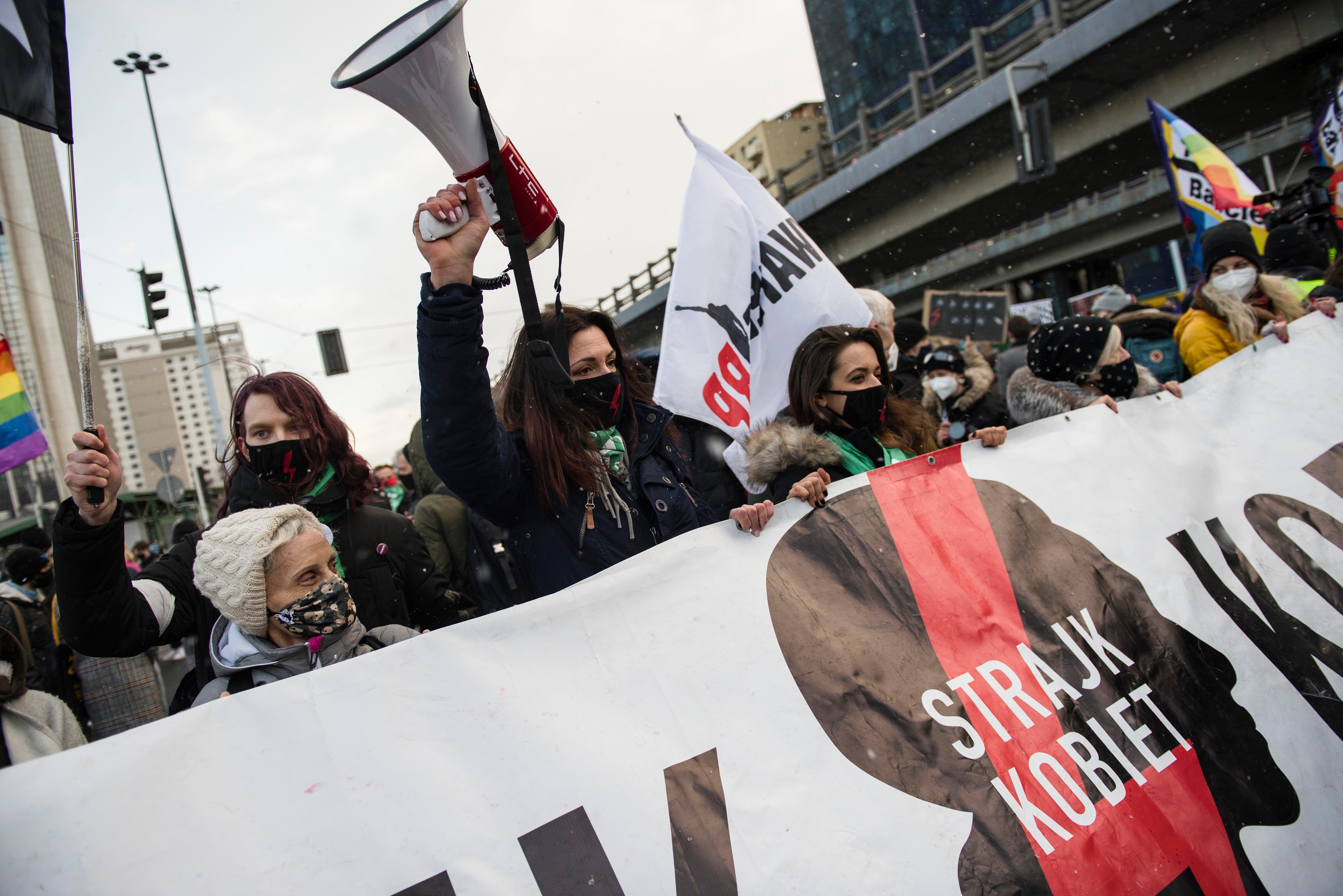 Protesters hold a banner of Strajk Kobiet (Women's Strike) during a protest in Warsaw on March 8,  International Women's Day, organized by the Women's Strike (Strajk Kobiet) against the ruling Law and Justice (PiS) party and the decision of the Constitutional Court.