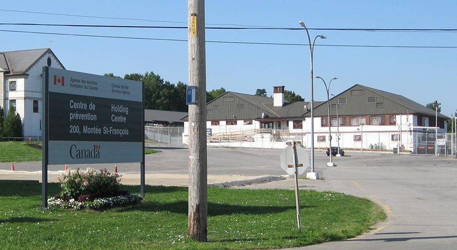 Entrance to the Canadian Border Security Agency's (CBSA) Laval Immigration Holding Centre in Quebec, Canada, showing a the entrance sign with the Canadian flag and the detention center in the background..