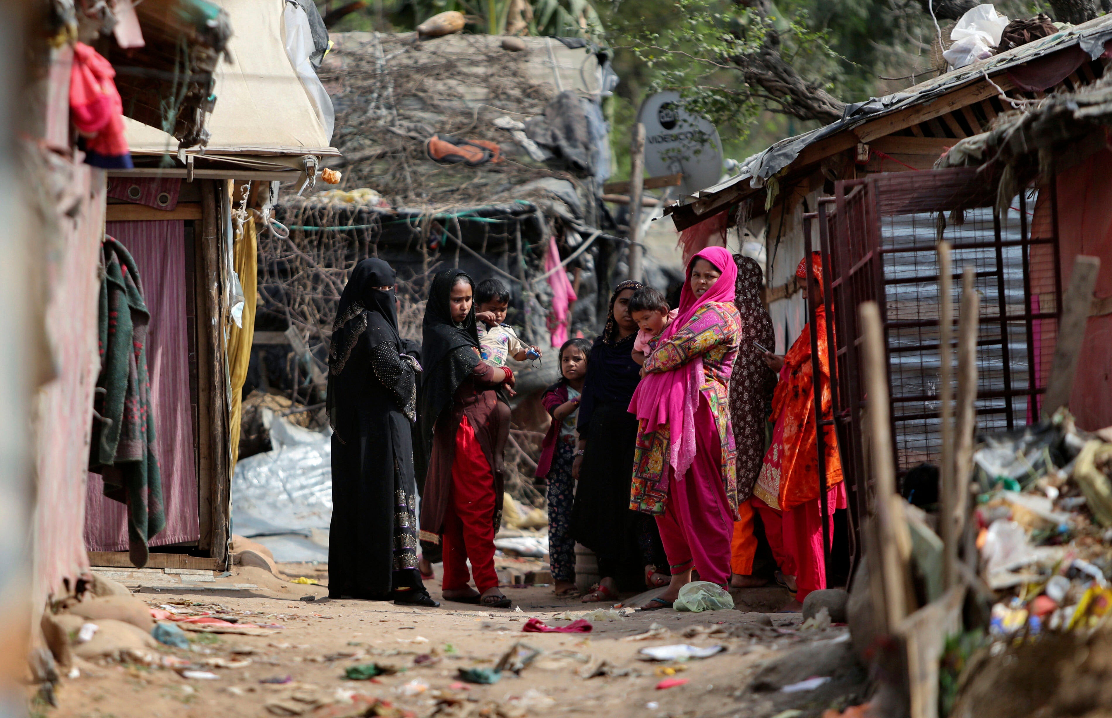 Rohingya refugees stand outside their makeshift camp on the outskirts of Jammu, India, March 7, 2021. 
