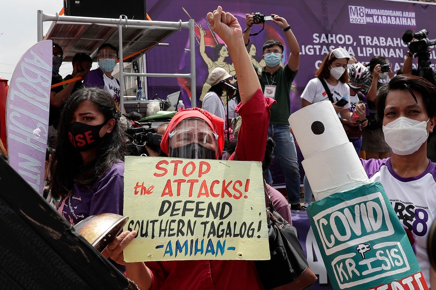 Protesters display slogans condemning the recent government attacks on activists during a rally near the Malacanang presidential palace on March 8, 2021 in Manila, Philippines.