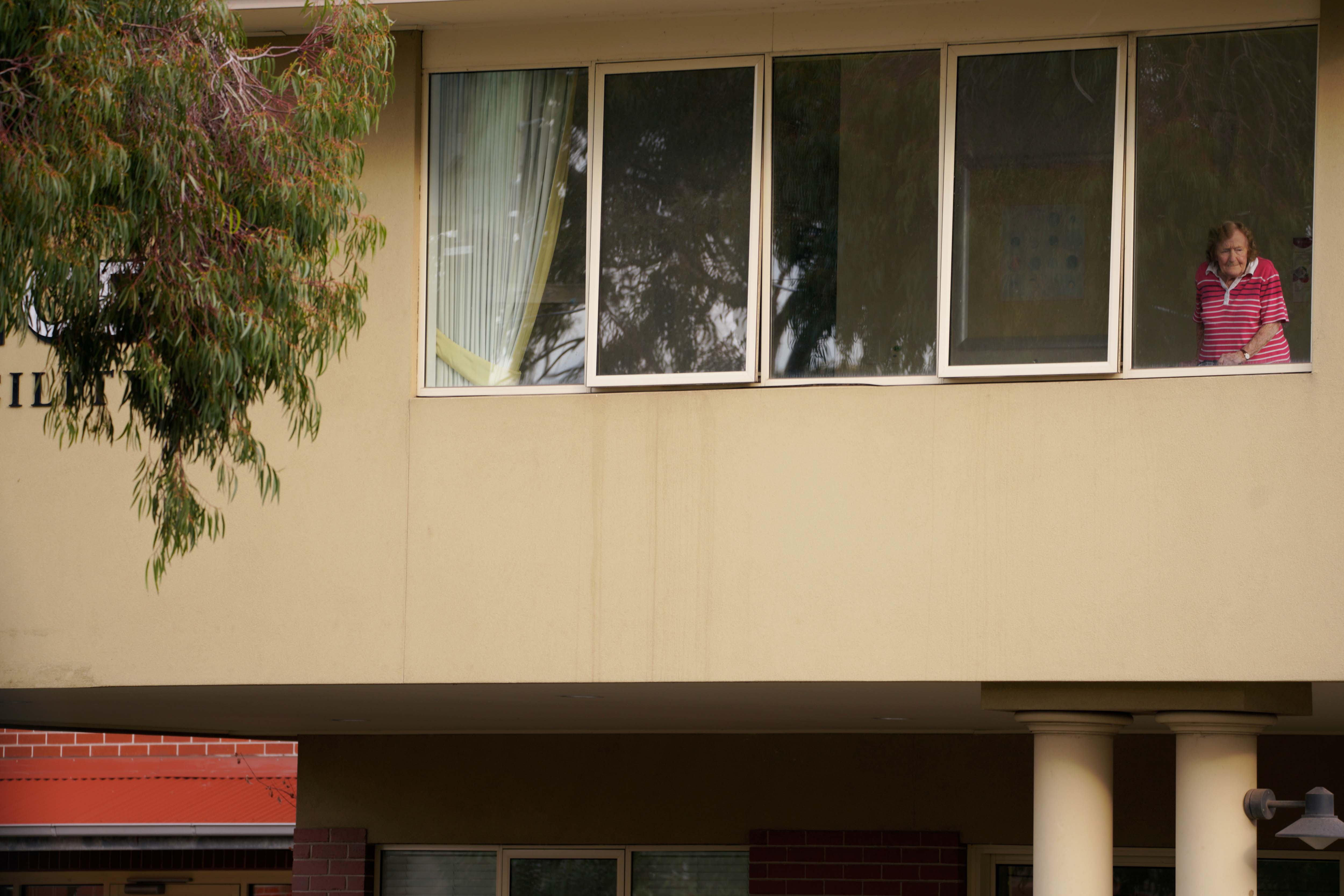 A resident looks out from the window of the Florence Aged Care Facility amid the second wave of the coronavirus disease (COVID-19) in Melbourne, Australia August 17, 2020.