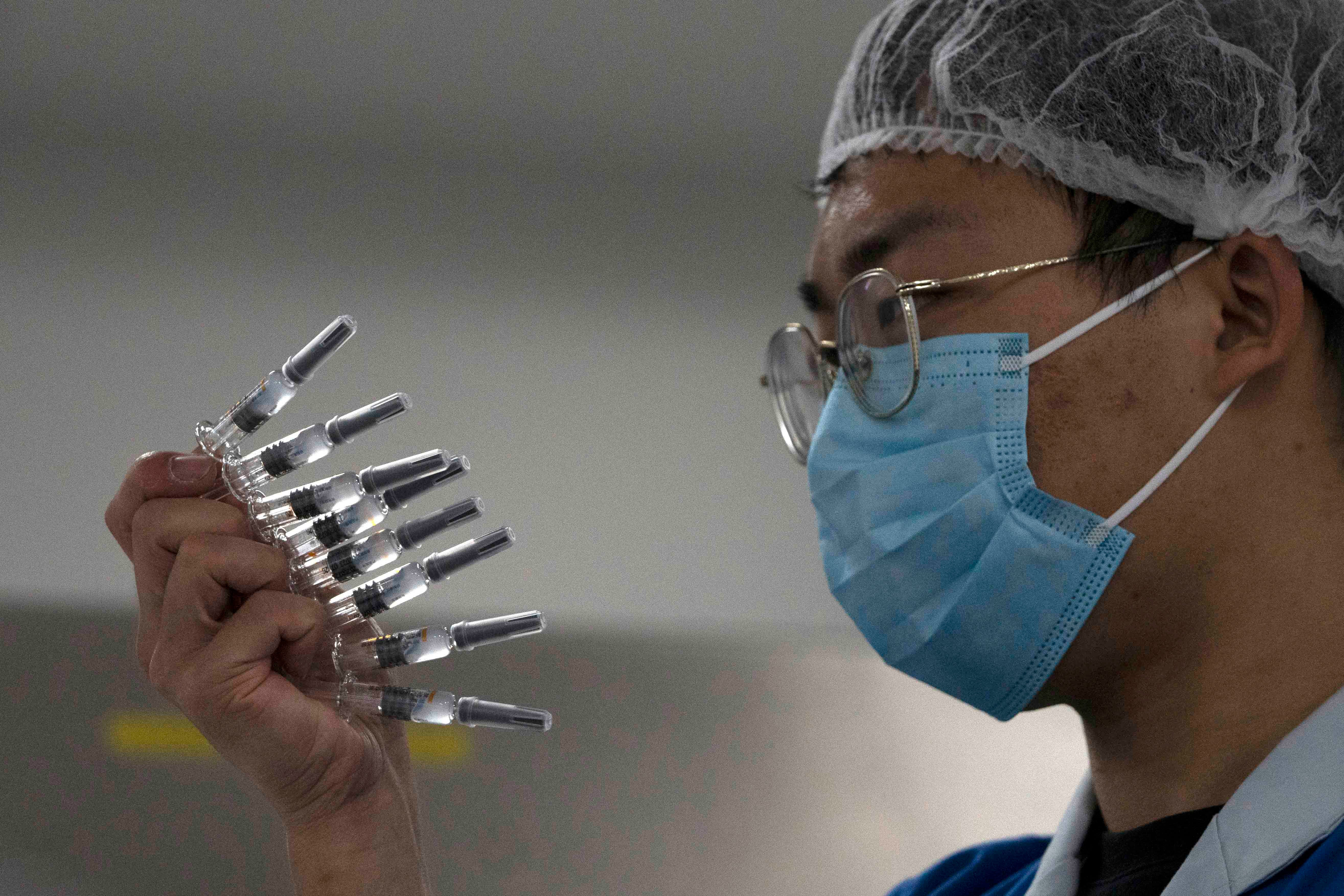 An employee manually inspects syringes of the SARS CoV-2 vaccine for Covid-19 in Beijing on September 24, 2020.