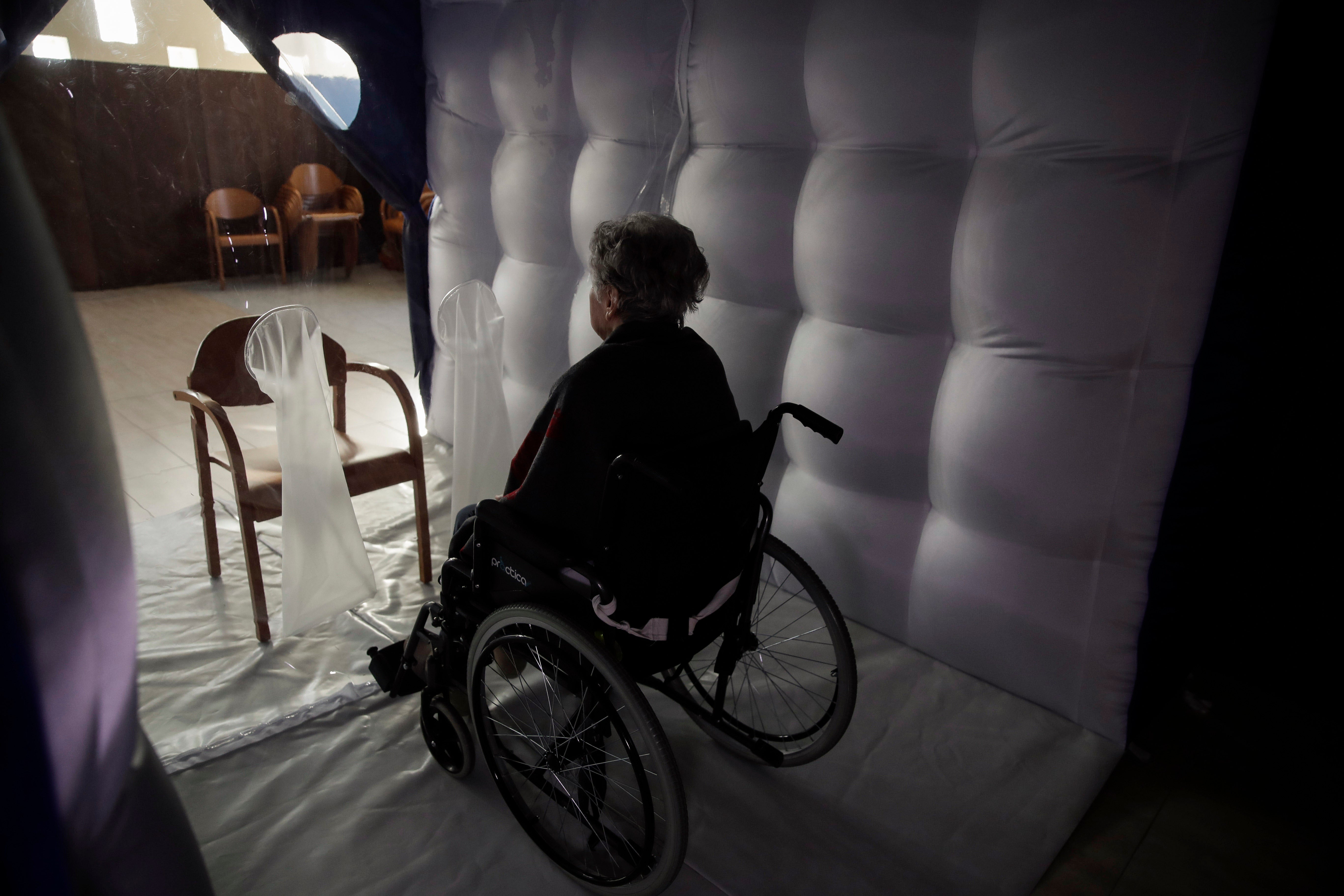 Caterina Salvi, 90, waits for a visitor inside a protective inflatable plastic tunnel at the Martino Zanchi nursing home in Alzano Lombardo, northern Italy, February 24, 2021. 