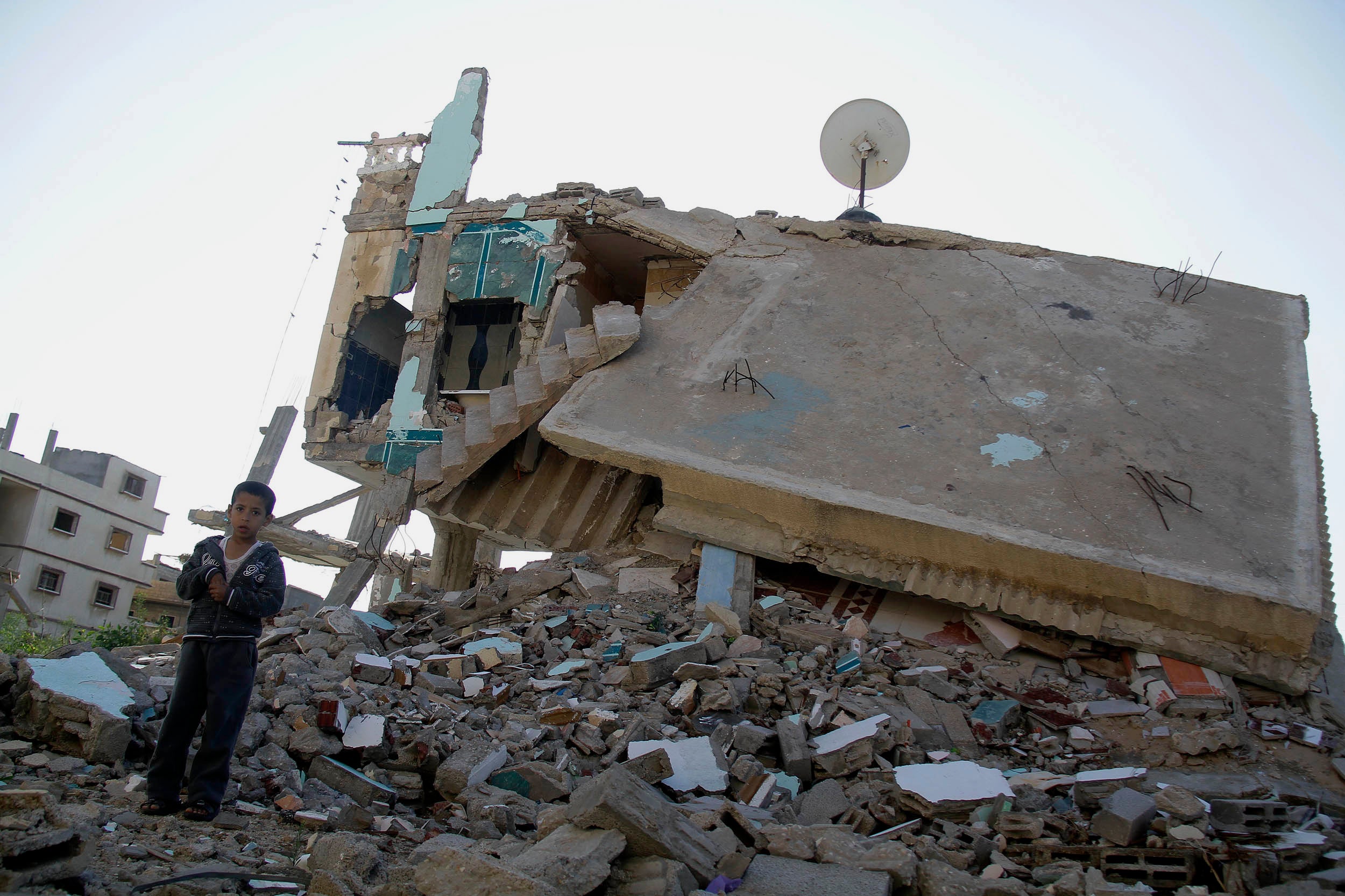 صبي يقف على  منزل دمره الجيش المصري في رفح، مصر، في وقت قريب من بداية الصراع المسلح في محافظة شمال سيناء  