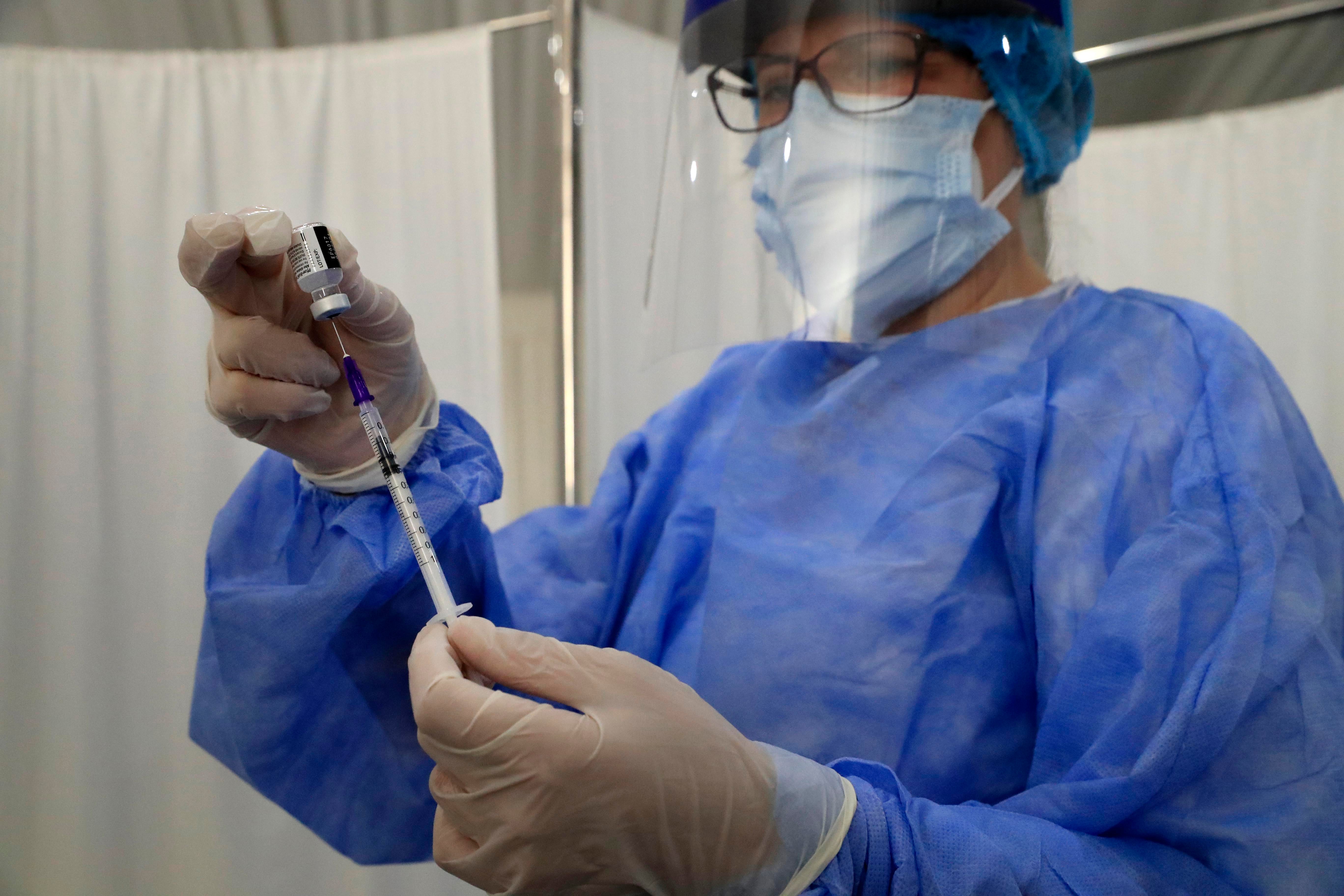 A nurse prepares a Covid-19 vaccine syringe at the Saint George Hospital in Beirut, Lebanon on February 16, 2021. © 2021 AP Photo/Hussein Malla