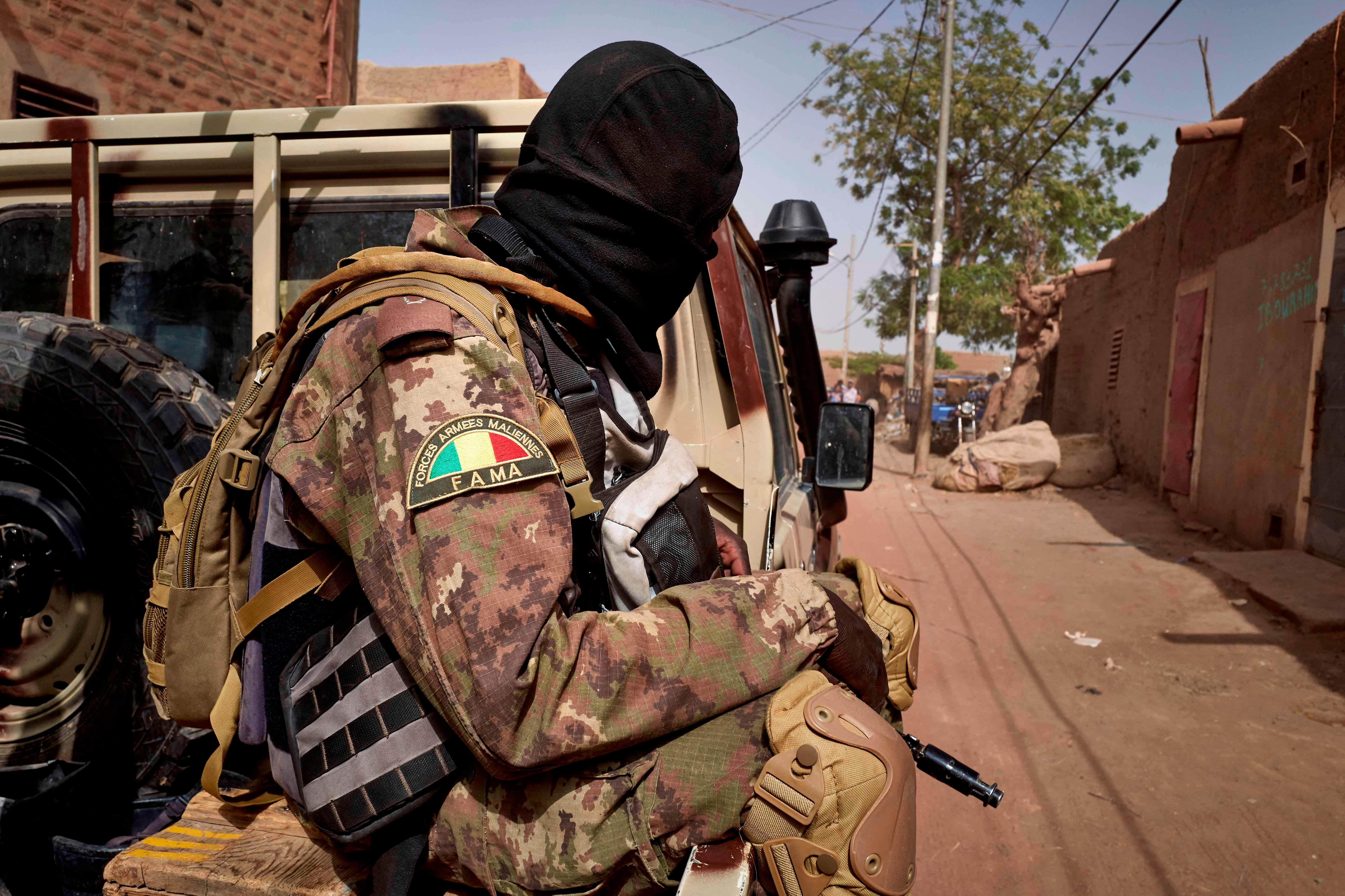 Un membre des Forces Armées Maliennes (FAMa), assis à l’arrière d’un véhicule patrouillant sur une route dans la région centrale du Mali, en février 2020.