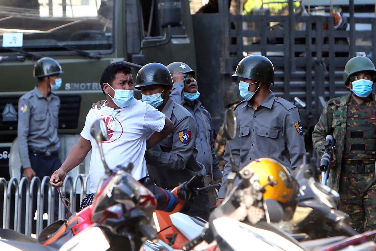 A man is held by police during a crackdown on anti-coup protesters holding a rally in front of the Myanmar Economic Bank in Mandalay, Myanmar on February 15, 2021.