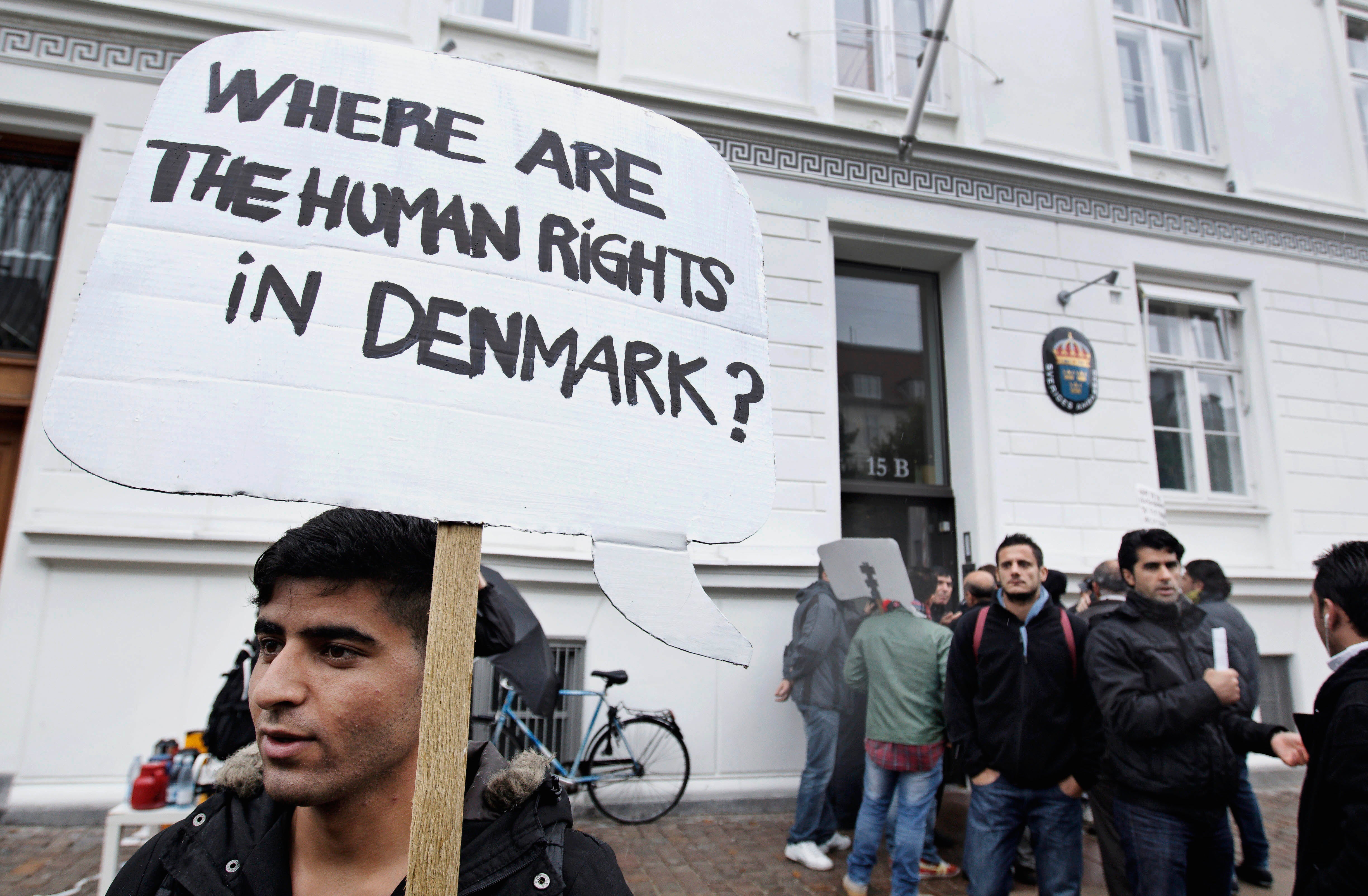 Syrian refugees hold banners outside the Swedish Embassy in Copenhagen, Denmark, protesting Denmark's asylum policies towards those who fled Syria's civil war, September 26, 2012.