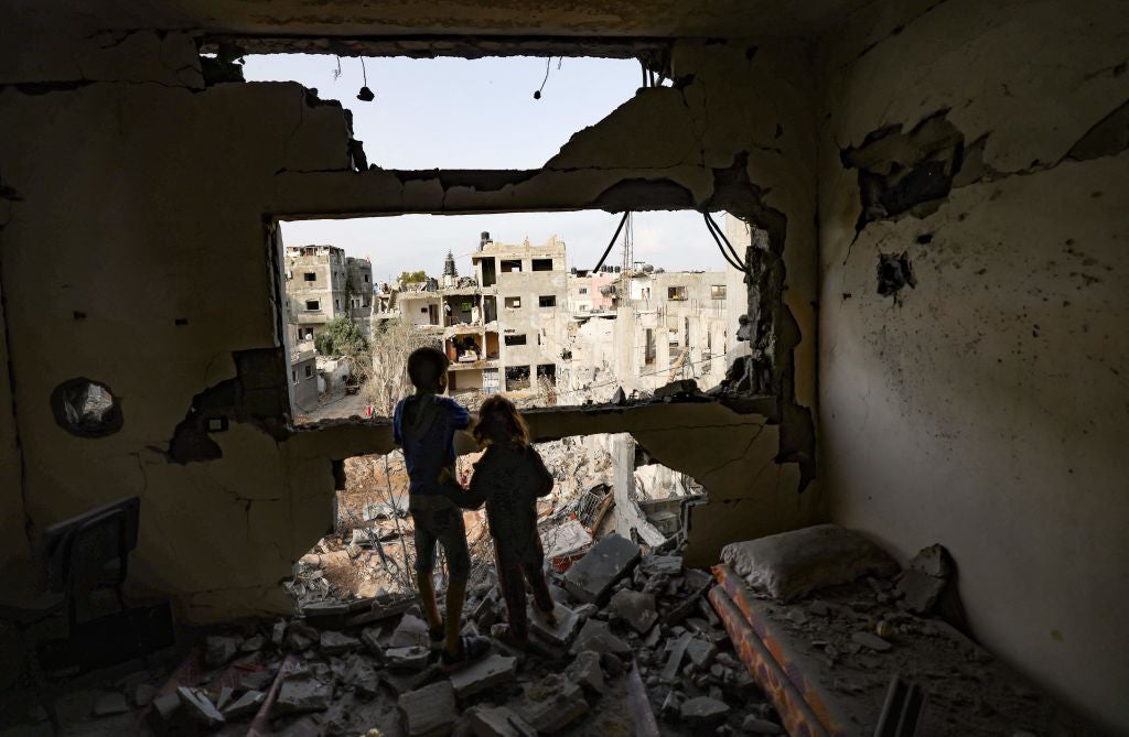 Palestinian children observe the damage from homes Gaza City