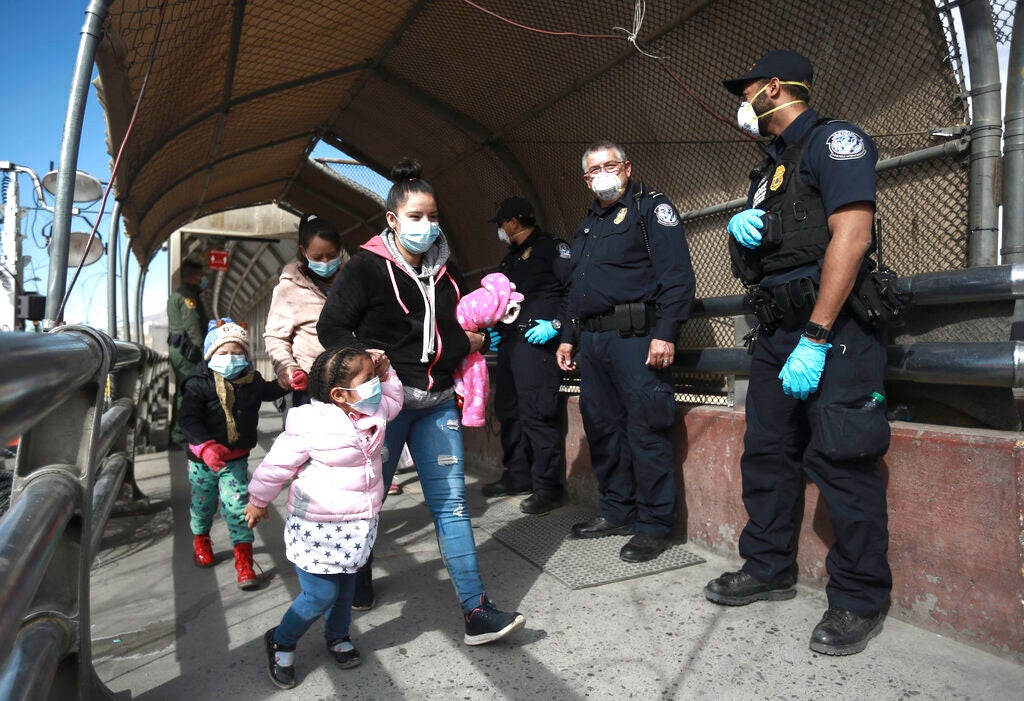 Una familia migrante cruza la frontera hacia El Paso, Texas, en Ciudad Juárez, México, el viernes 26 de febrero de 2021.