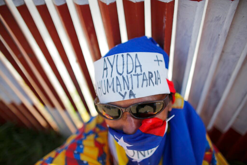 In this Feb. 23, 2019 file photo, an opposition supporter wears a message on his forehead that reads in Spanish: "Humanitarian aid now," during a demonstration urging soldiers to allow the entry of U.S. humanitarian aid, in Caracas, Venezuela.