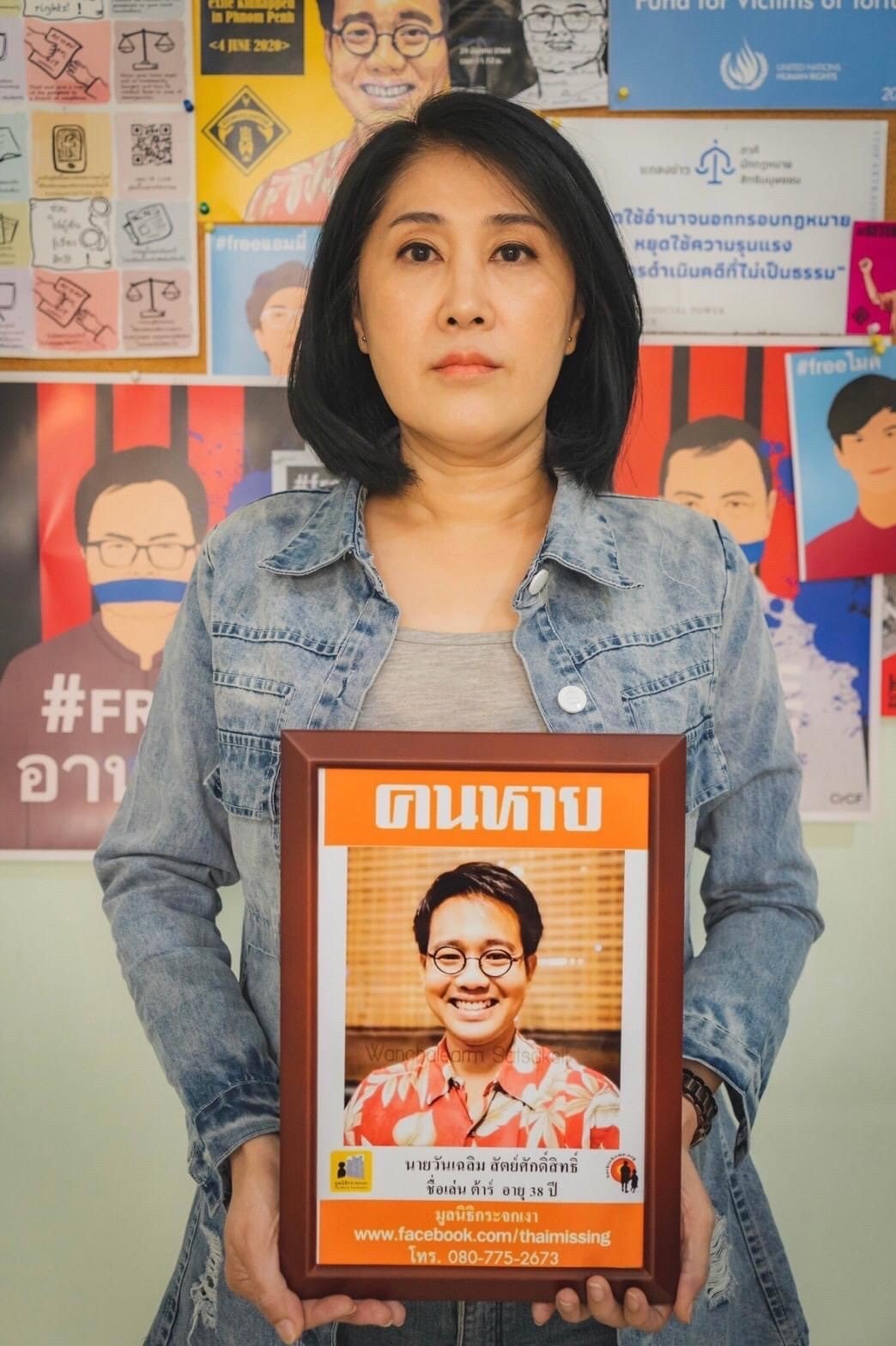 Sitanun Satsaksit holds a portrait of her brother, Wanchalearm, who was forcibly disappeared while living in exile in Cambodia on June 4, 2020. 