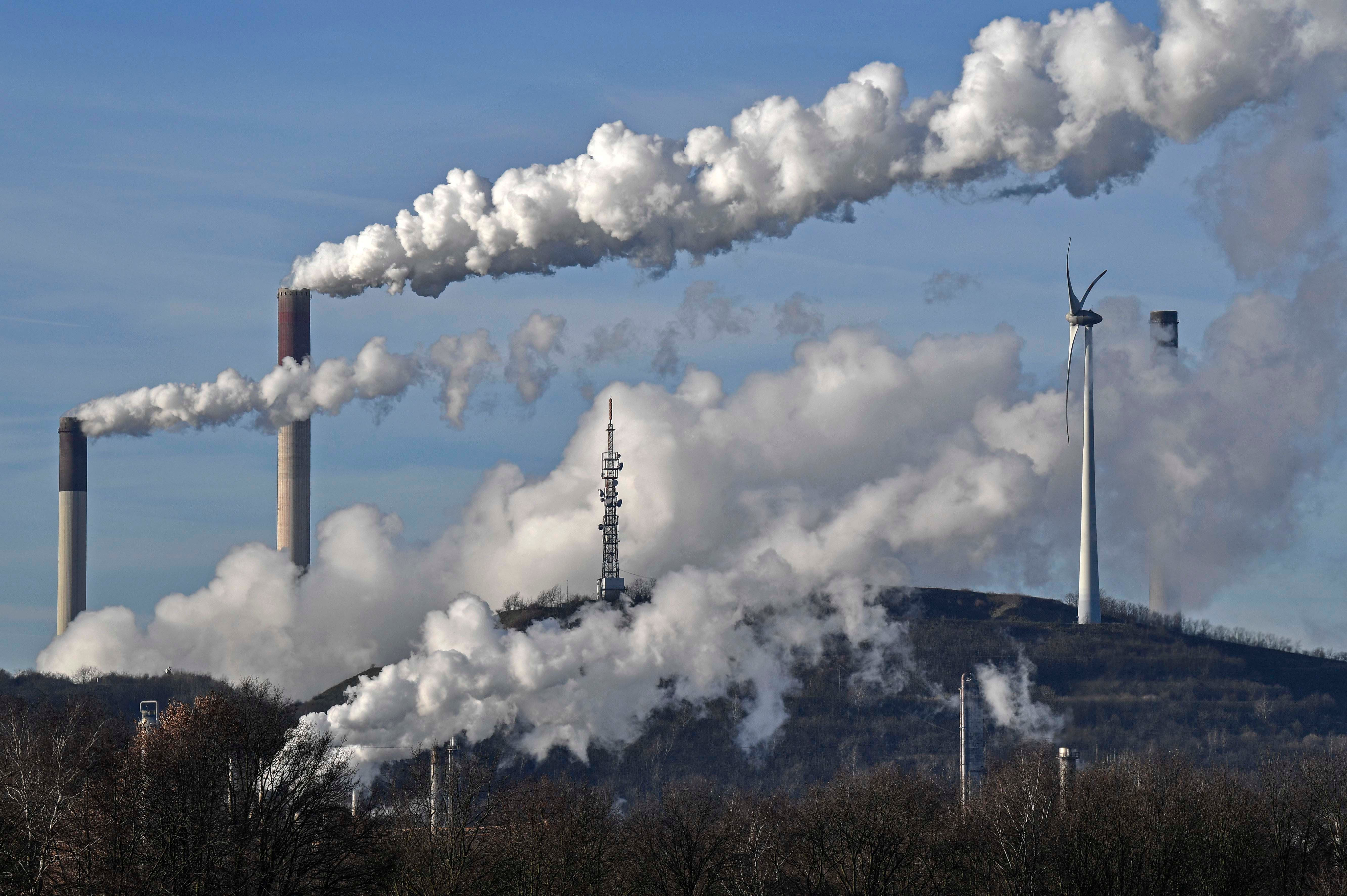 A Uniper coal-fired power plant and a BP refinery steam beside a wind generator in Gelsenkirchen, Germany on Jan. 16, 2020. © 2020 Martin Meissner/AP Photo