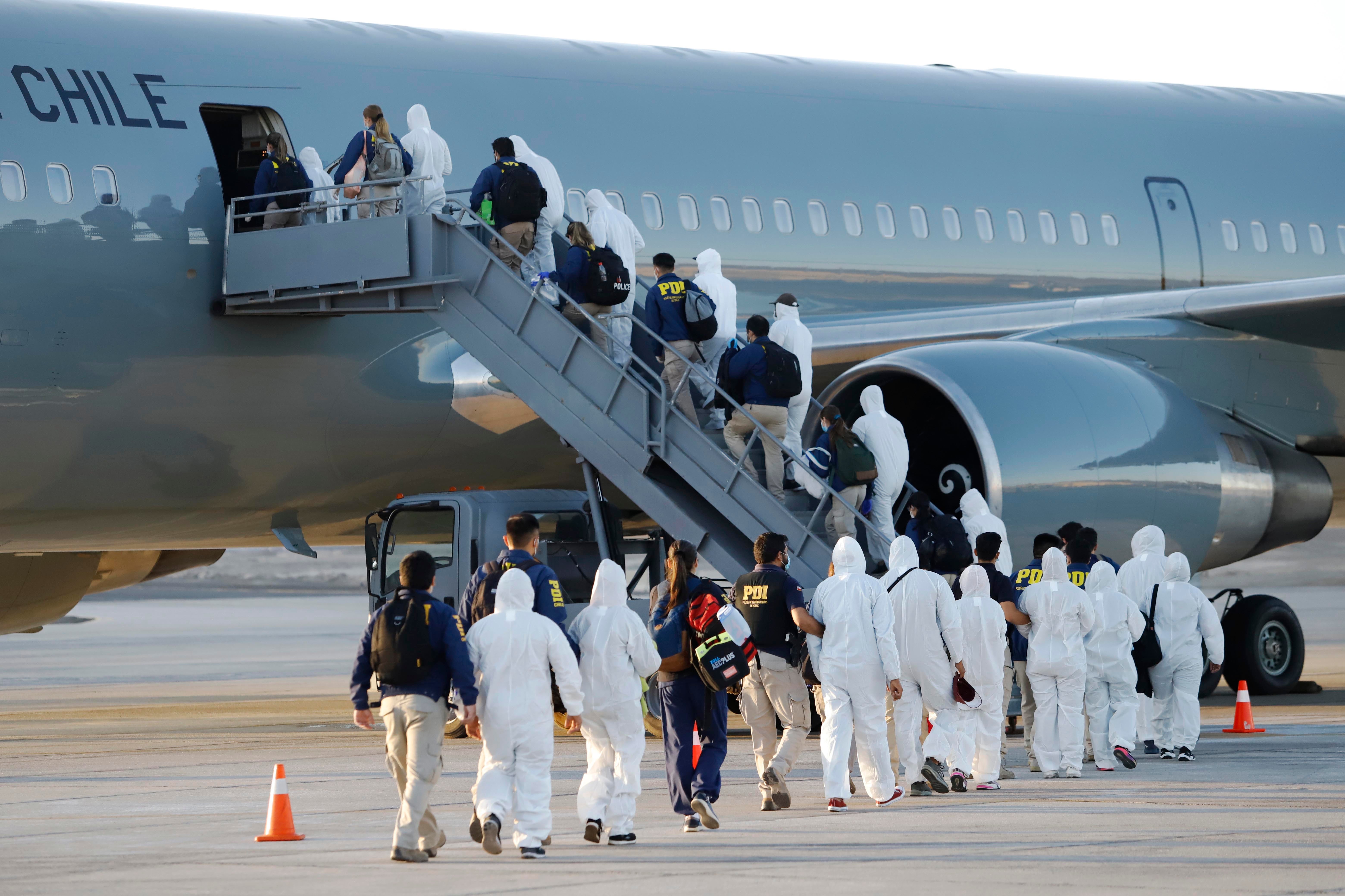Venezuelan migrants board a plane as they are being deported from Chile, at the General Diego Aracena Aguilar International Airport in Iquique, Chile, on February 10, 2021. 