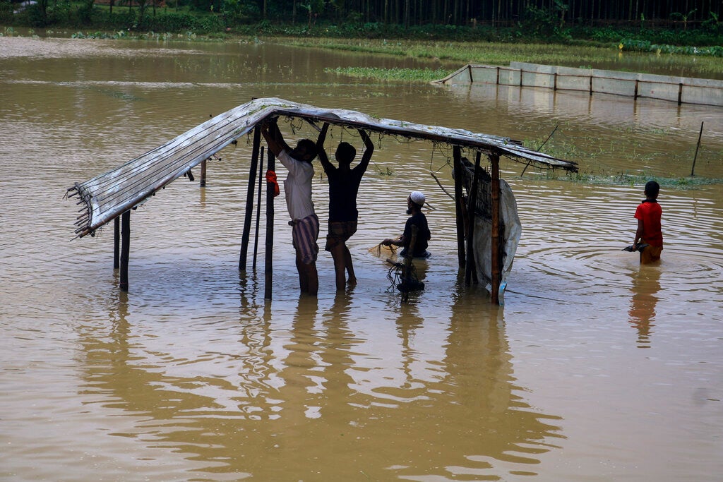 Rohingya refugees repair a shelter damaged following heavy rains at the refugee camp in Kutupalong, Bangladesh on July 28, 2021.