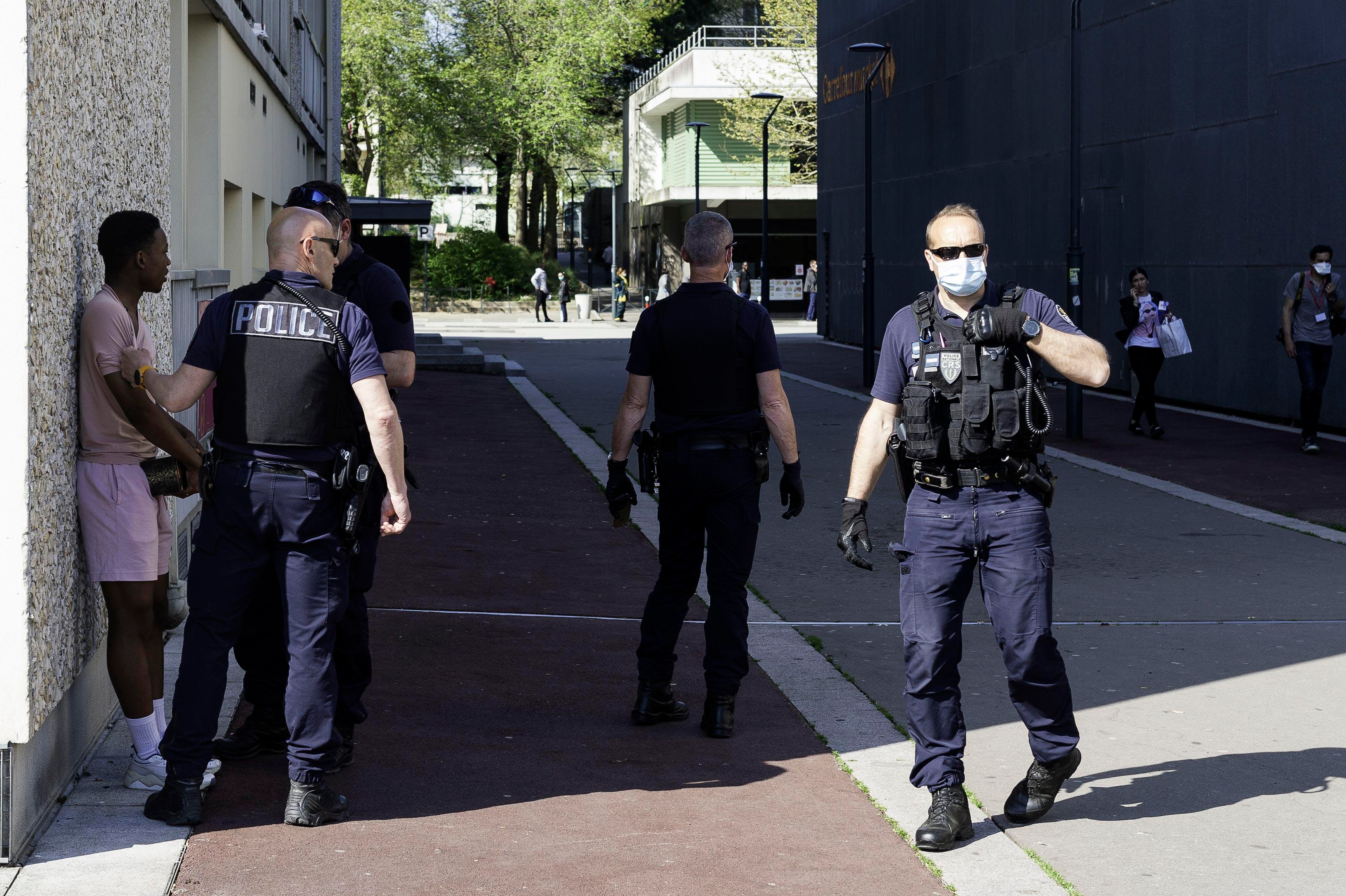 Police agents check identity documents of passerby during the lockdown in Rennes, France. April 11, 2020. 