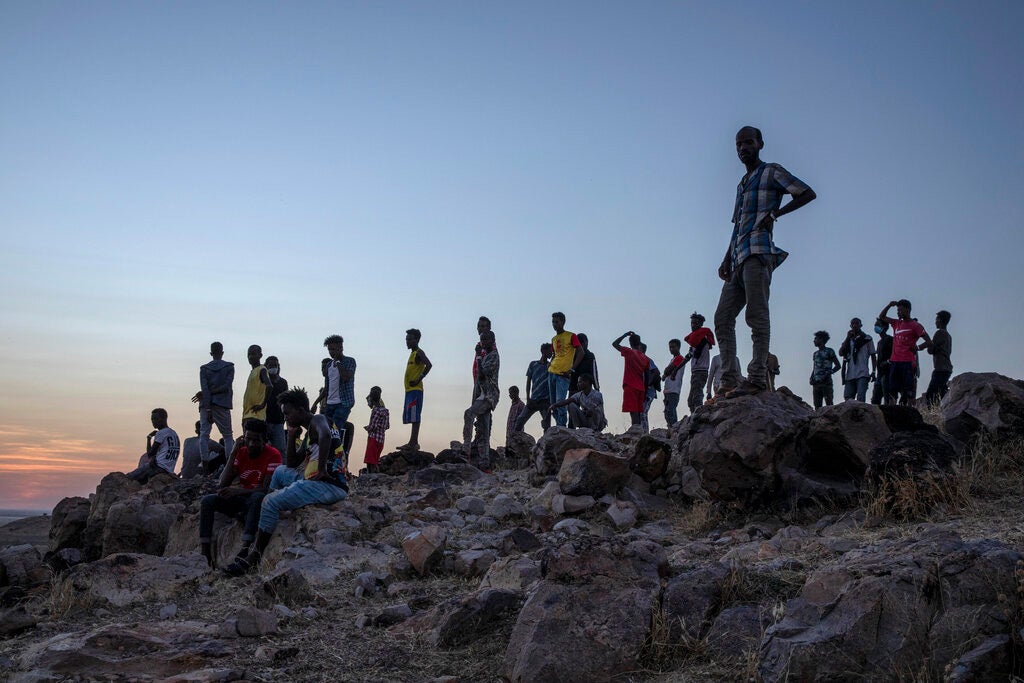 Tigrayans who fled the conflict in Ethiopia's Tigray region stand on a hilltop overlooking Umm Rakouba refugee camp in Qadarif, eastern Sudan, November 26, 2020