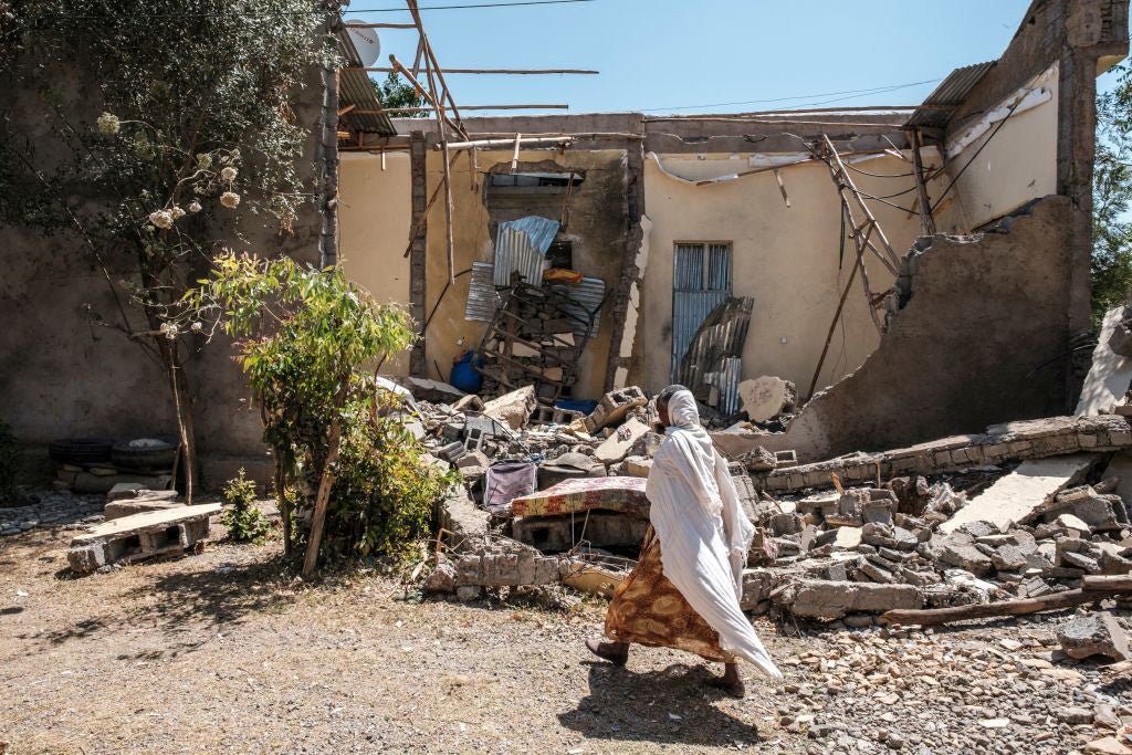 A woman walks past a house that was damaged by shelling when federal-aligned forces entered the town of Wukro, in Ethiopia's Tigray region, March 1, 2021. 