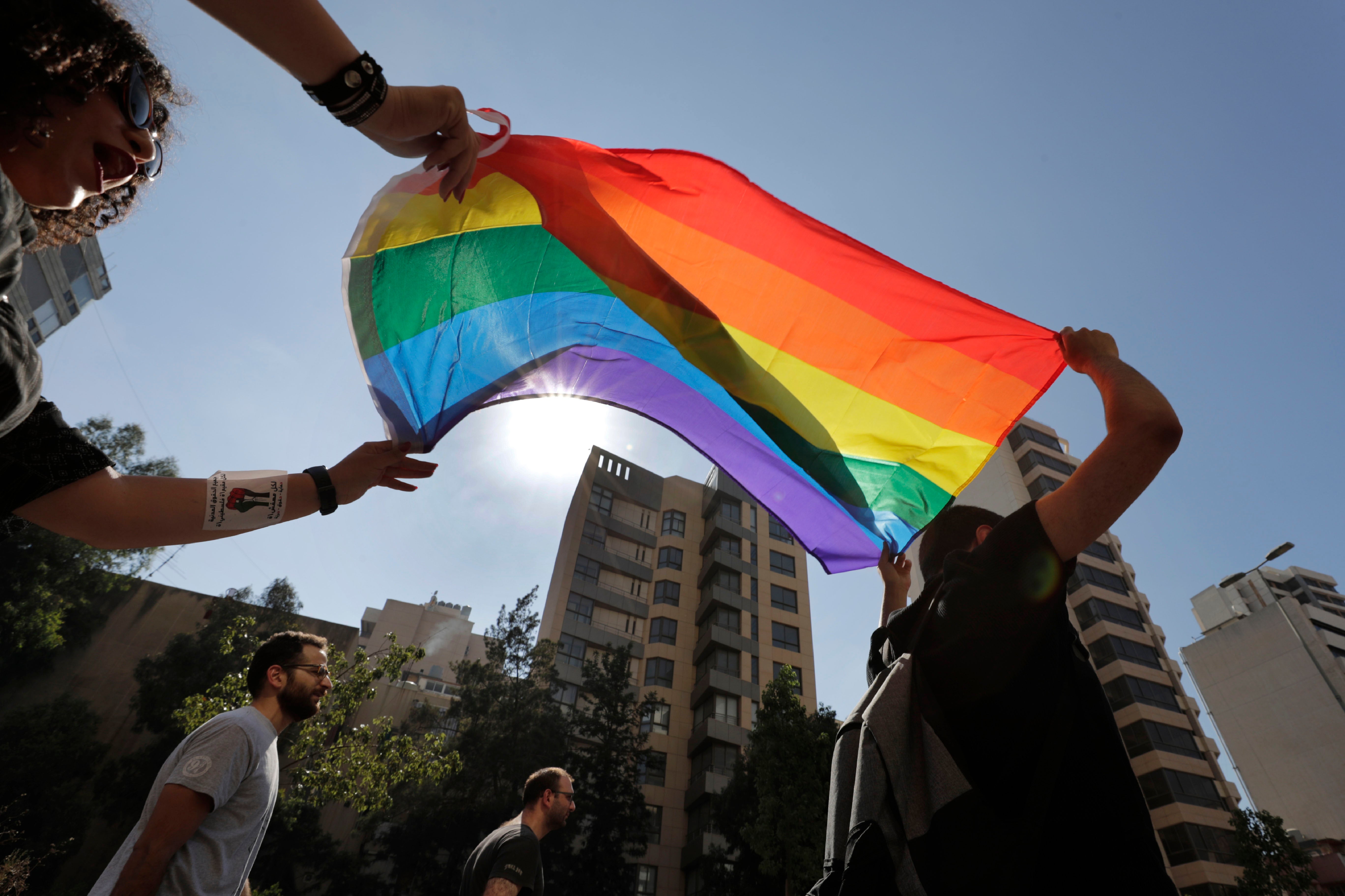 LGBT activists in Beirut, Lebanon shout slogans and hold up a rainbow flag as they march to demand equal rights in a country gripped by economic and financial crisis, June 27, 2020.