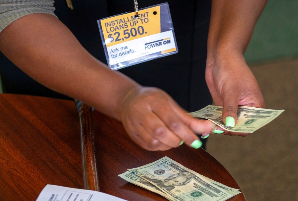 A manager of a financial services counts cash being paid to a client as part of a loan in Ballwin, Missouri on August 9, 2018