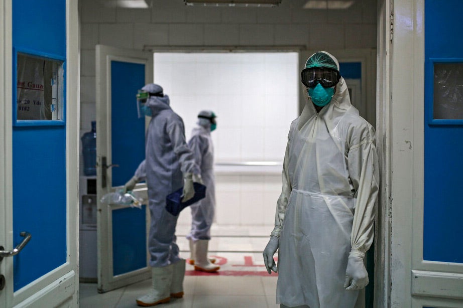 A medical worker wearing full protective gear stands at the gate of the intensive care unit of a hospital, where coronavirus (Covid-19) patients are treated in Sanaa, Yamen, on June 15, 2020.