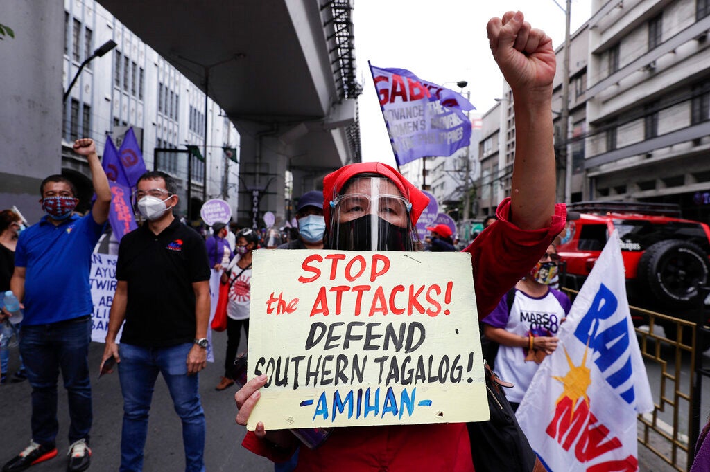 A woman carries a slogan condemning government attacks on activists at a rally to mark International Women's Day, Manila, Philippines on March 8, 2021.