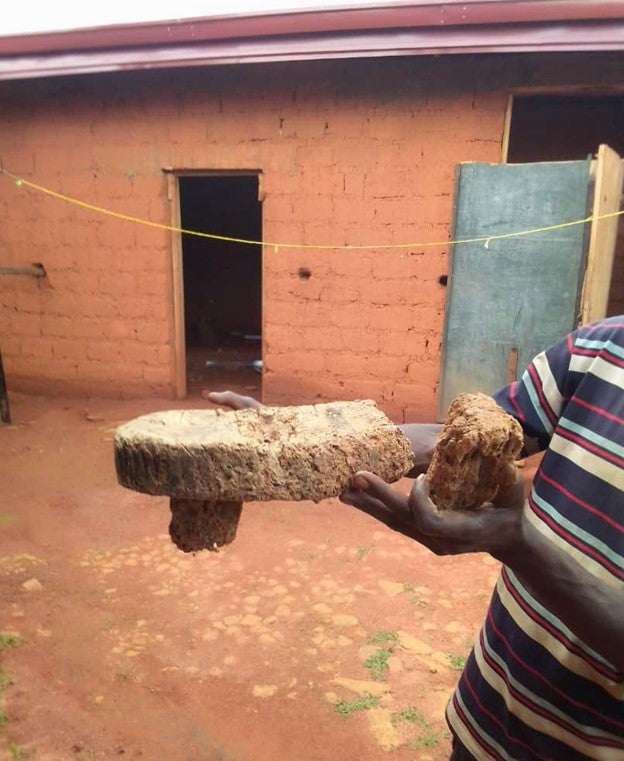 Un homme tient ce qui reste du trône royal ancestral du « Fon », l’autorité traditionnelle du village de Ndzeen. Il a été délibérément détruit par des militaires camerounais lors d’une opération de sécurité dans le village, le 9 juin 2021. 9 juin 2021, résidence du "Fon", Ndzeen, région du Nord-Ouest, Cameroun. 