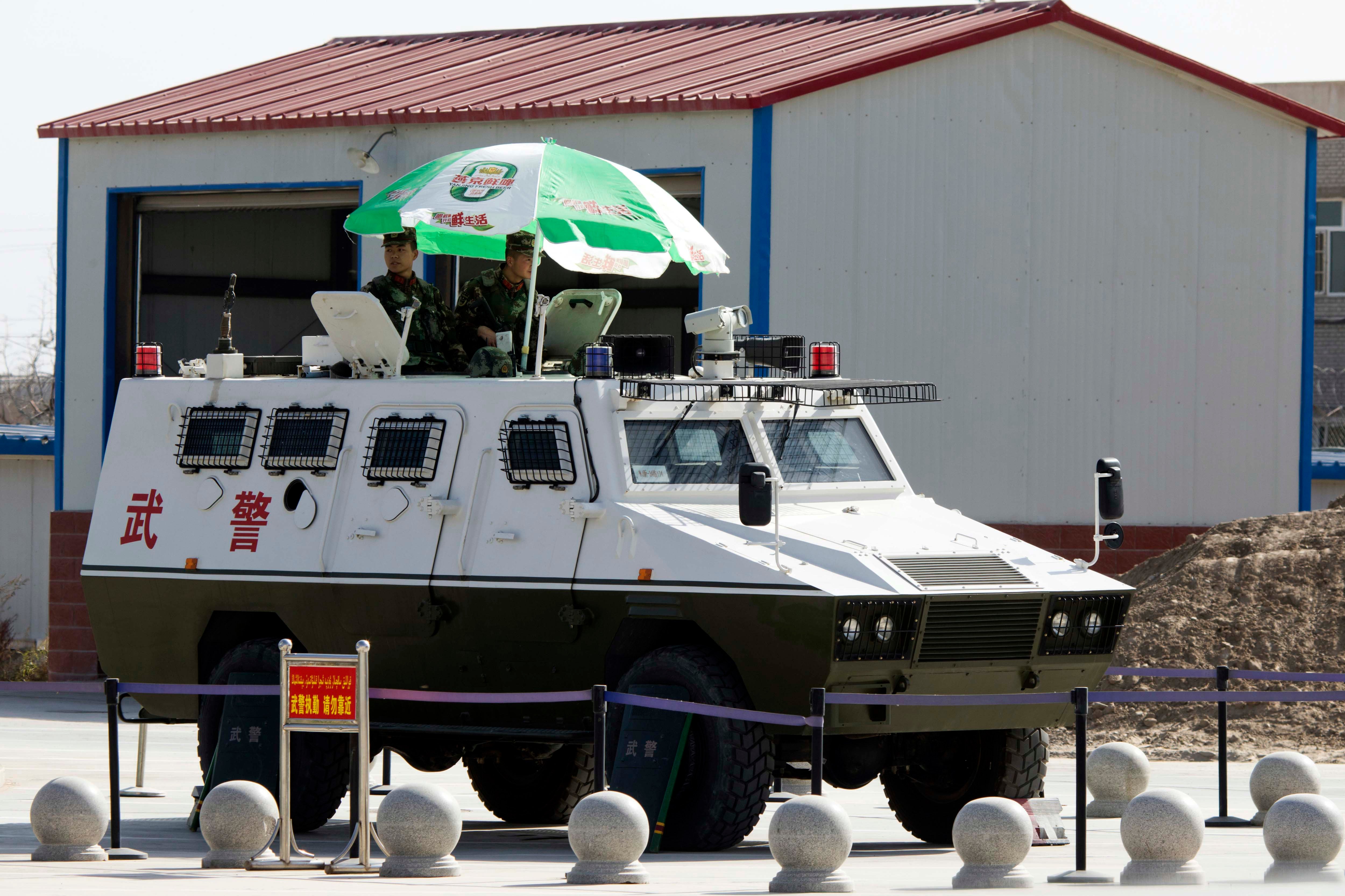 Two soldiers ride in an armored vehicle